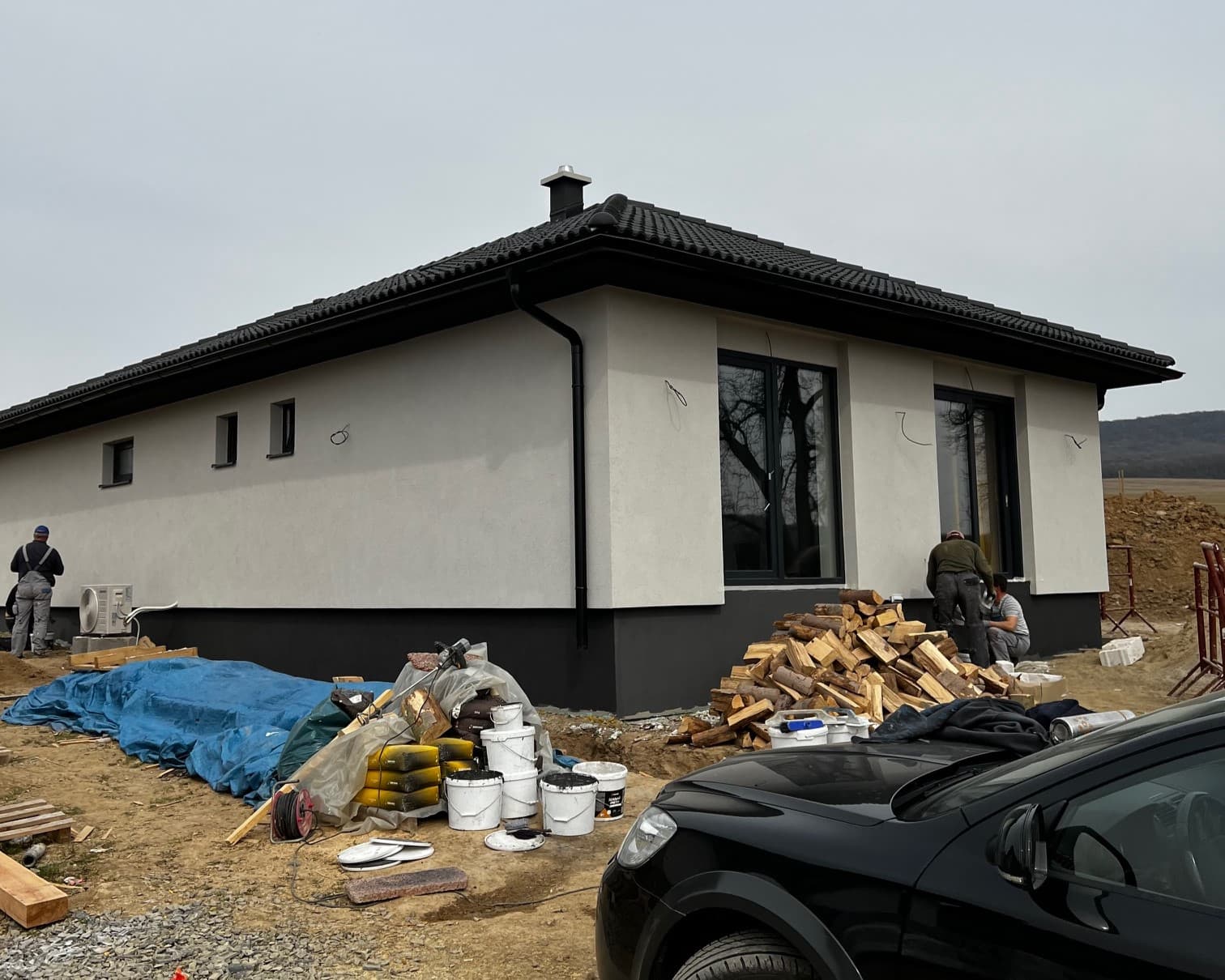 Luxusná obývačka s drevenými prvkami, zabudovanou knižnicou, moderným osvetlením, elegantným nábytkom a umeleckými obrazmi na stenách.