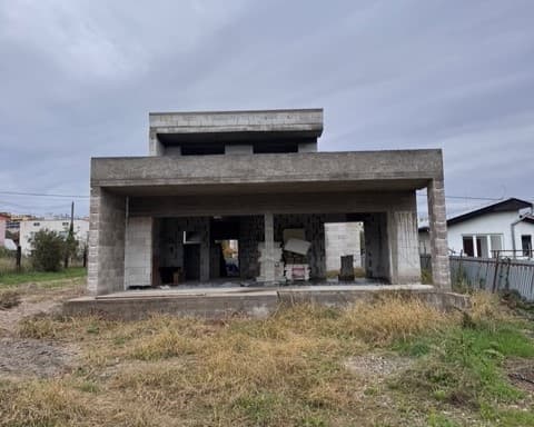 Moderný interiér s otvorenou kuchyňou, štýlovým osvetlením, pohodlnou sedačkou a jedálenským stolom v elegantných neutrálnych tónoch.