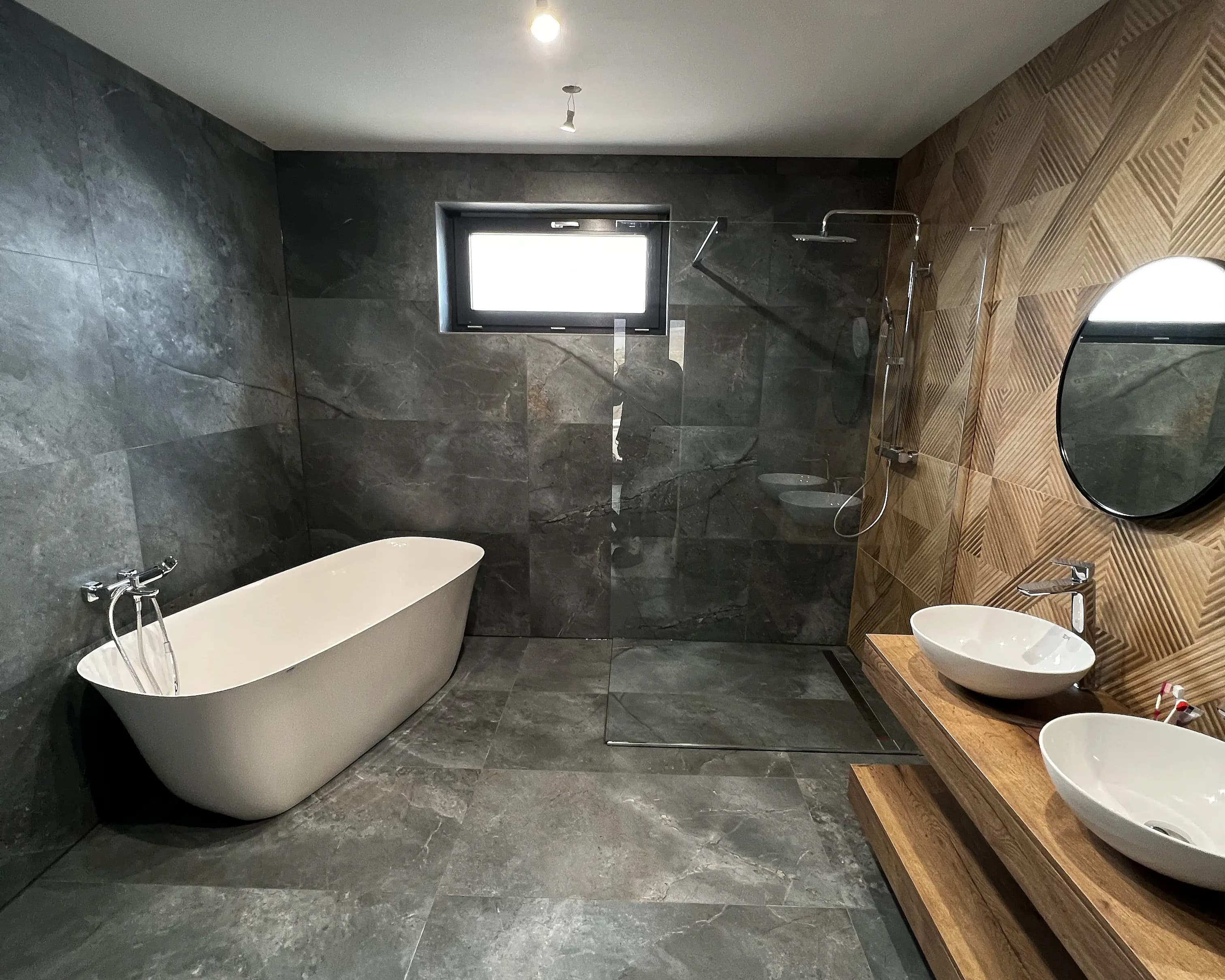 Luxusná obývačka s drevenými prvkami, zabudovanou knižnicou, moderným osvetlením, elegantným nábytkom a umeleckými obrazmi na stenách.