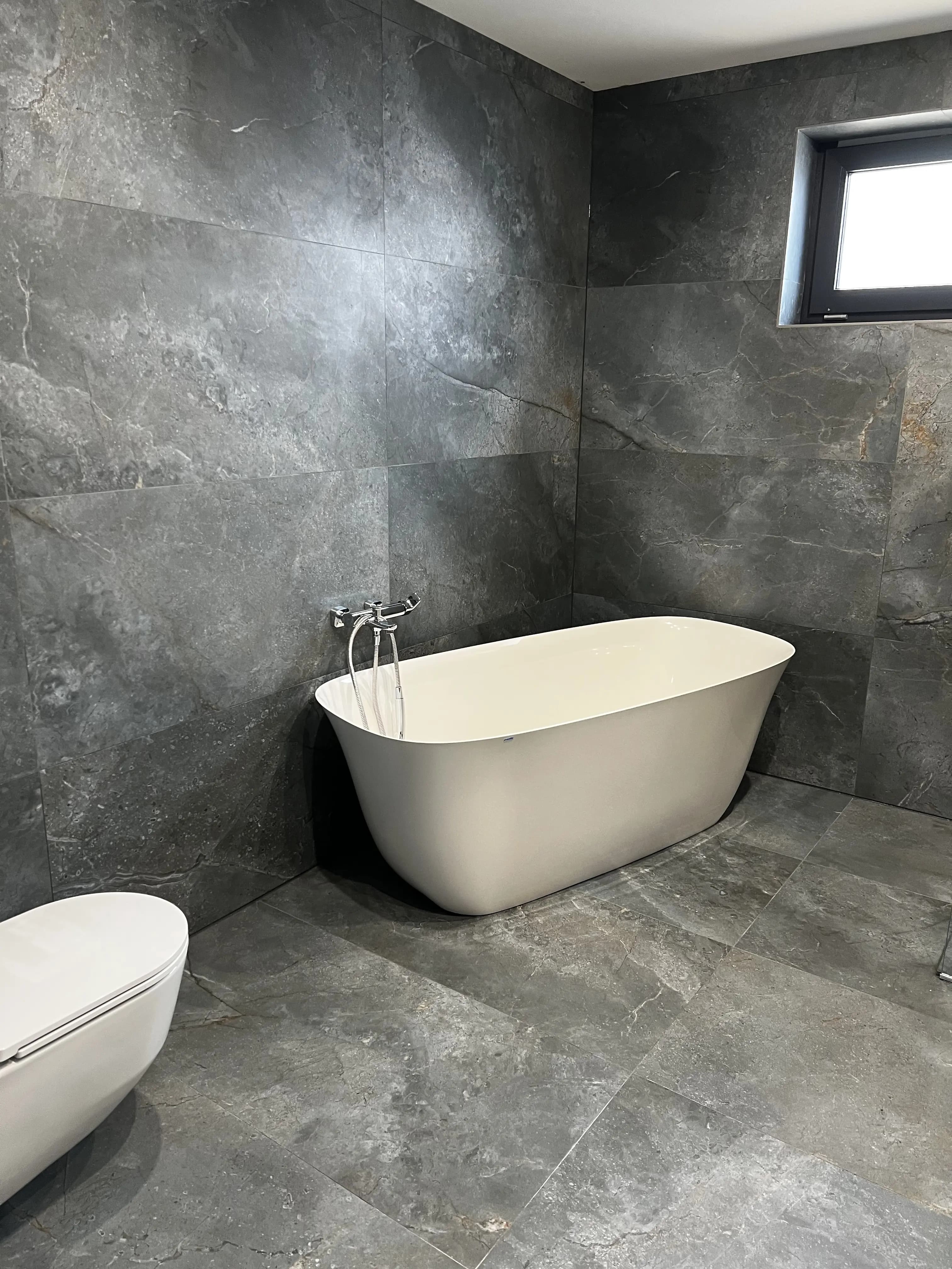 Moderná kancelária v minimalistickom štýle s elegantnými pracovnými stolmi a prírodnými materiálmi.