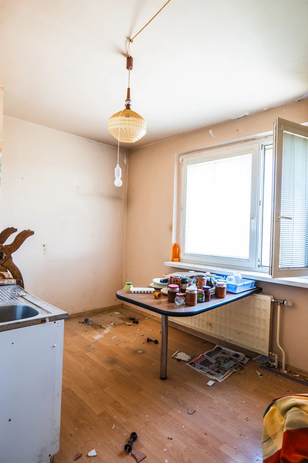 Štýlová tmavá kuchyňa s moderným osvetlením, zlatými akcentmi a elegantným jedálenským stolom.