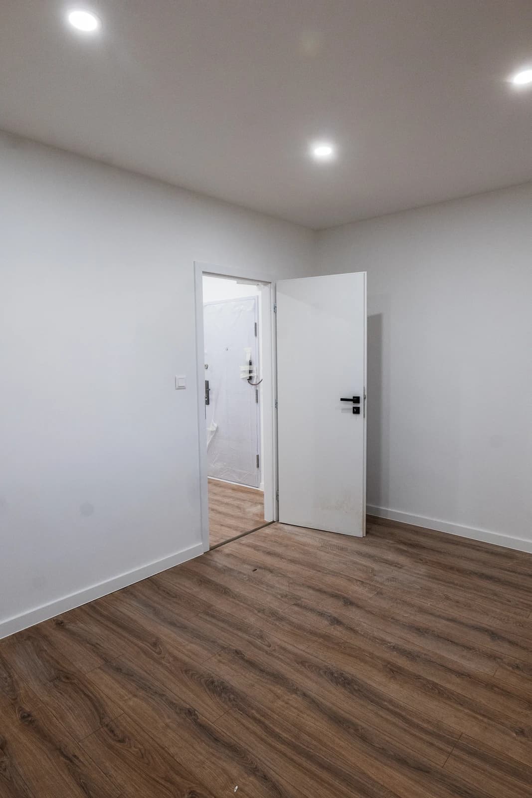 Štýlová tmavá kuchyňa s moderným osvetlením, zlatými akcentmi a elegantným jedálenským stolom.