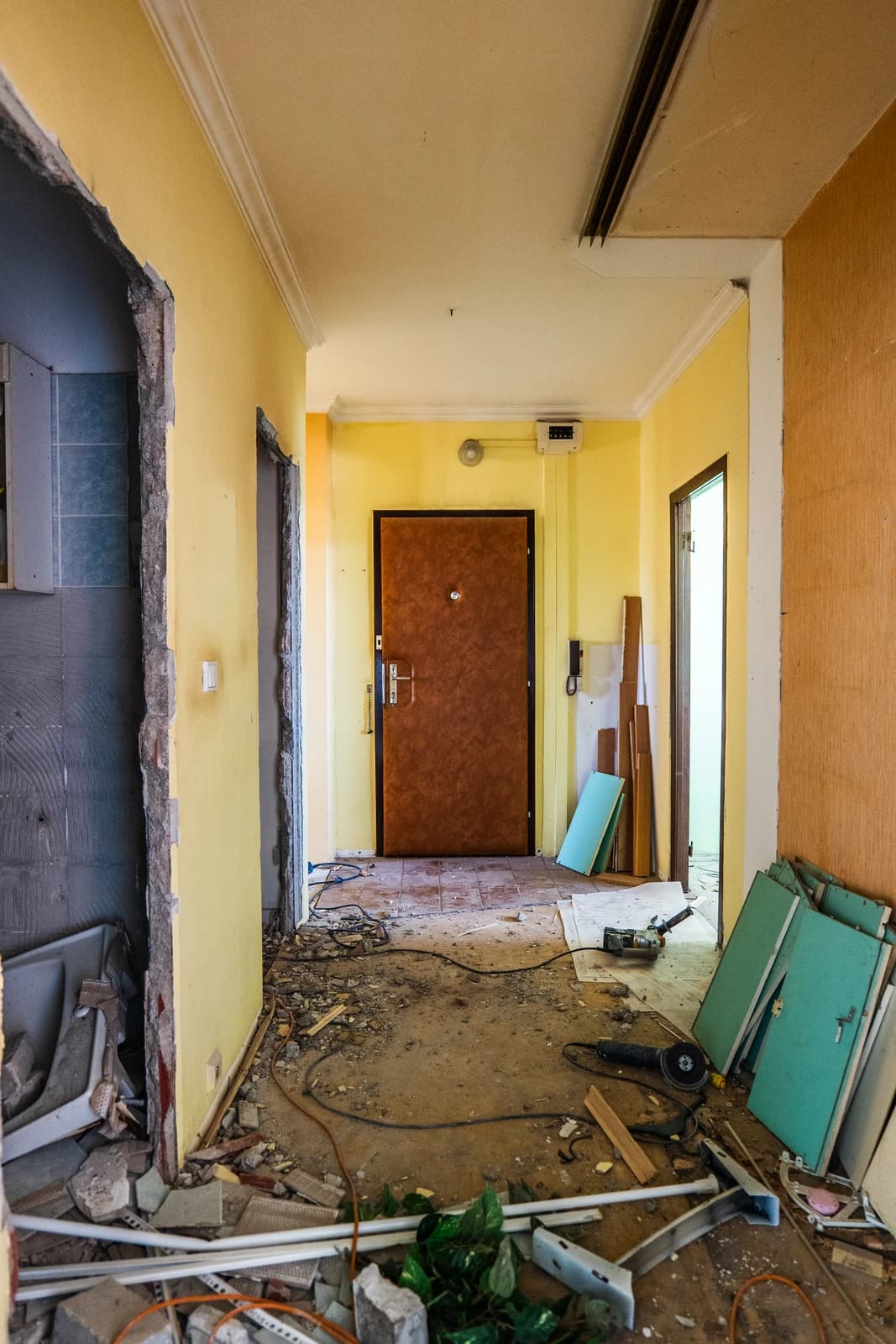 Štýlová tmavá kuchyňa s moderným osvetlením, zlatými akcentmi a elegantným jedálenským stolom.