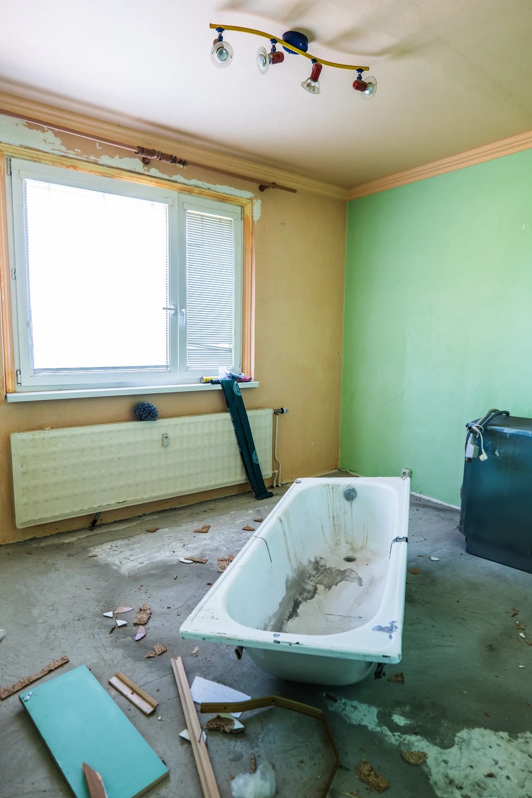 Štýlová tmavá kuchyňa s moderným osvetlením, zlatými akcentmi a elegantným jedálenským stolom.