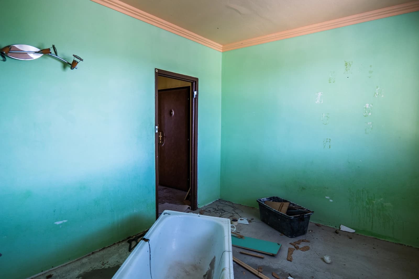 Štýlová tmavá kuchyňa s moderným osvetlením, zlatými akcentmi a elegantným jedálenským stolom.