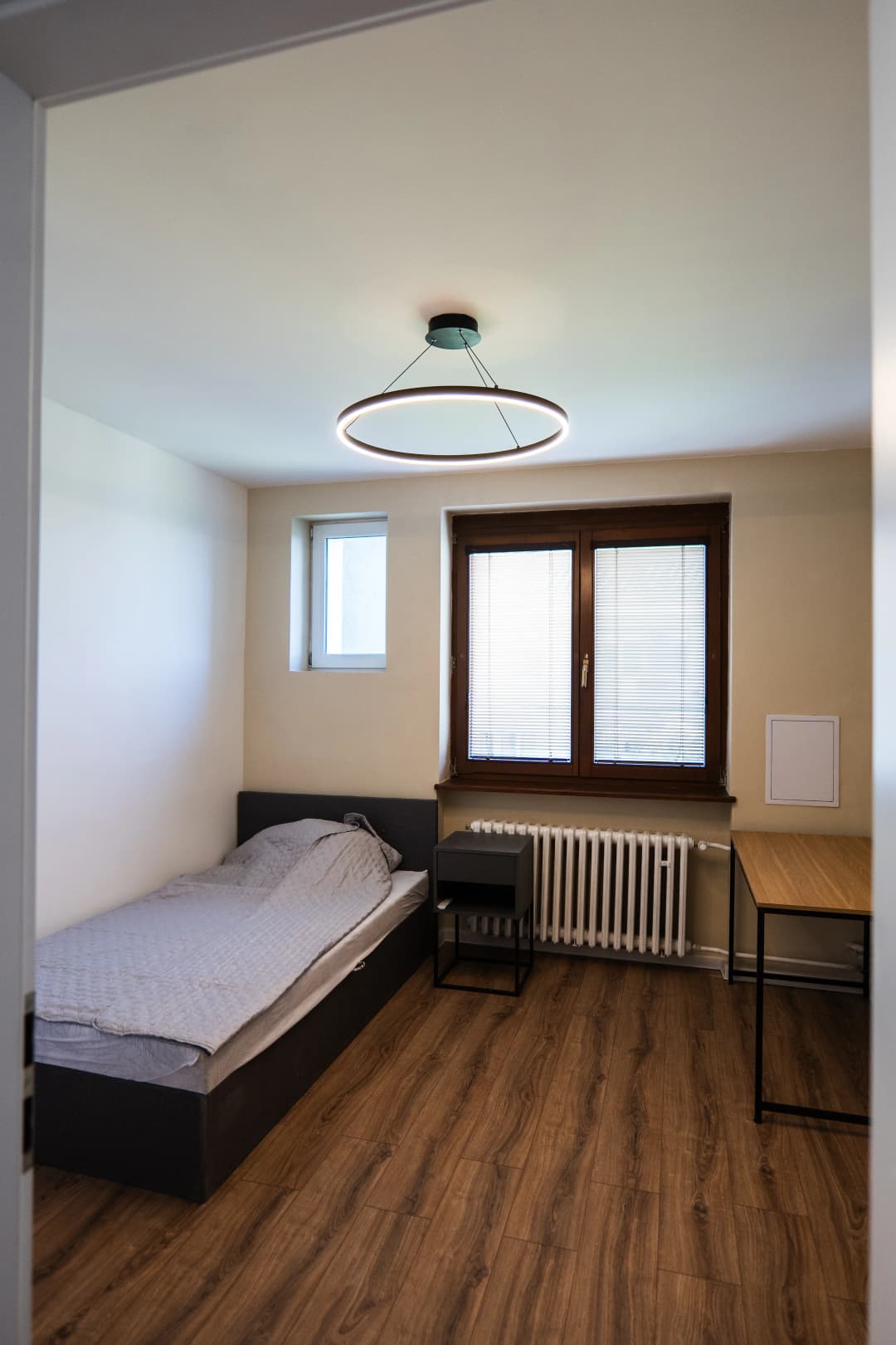 Moderná kancelária v minimalistickom štýle s elegantnými pracovnými stolmi a prírodnými materiálmi.