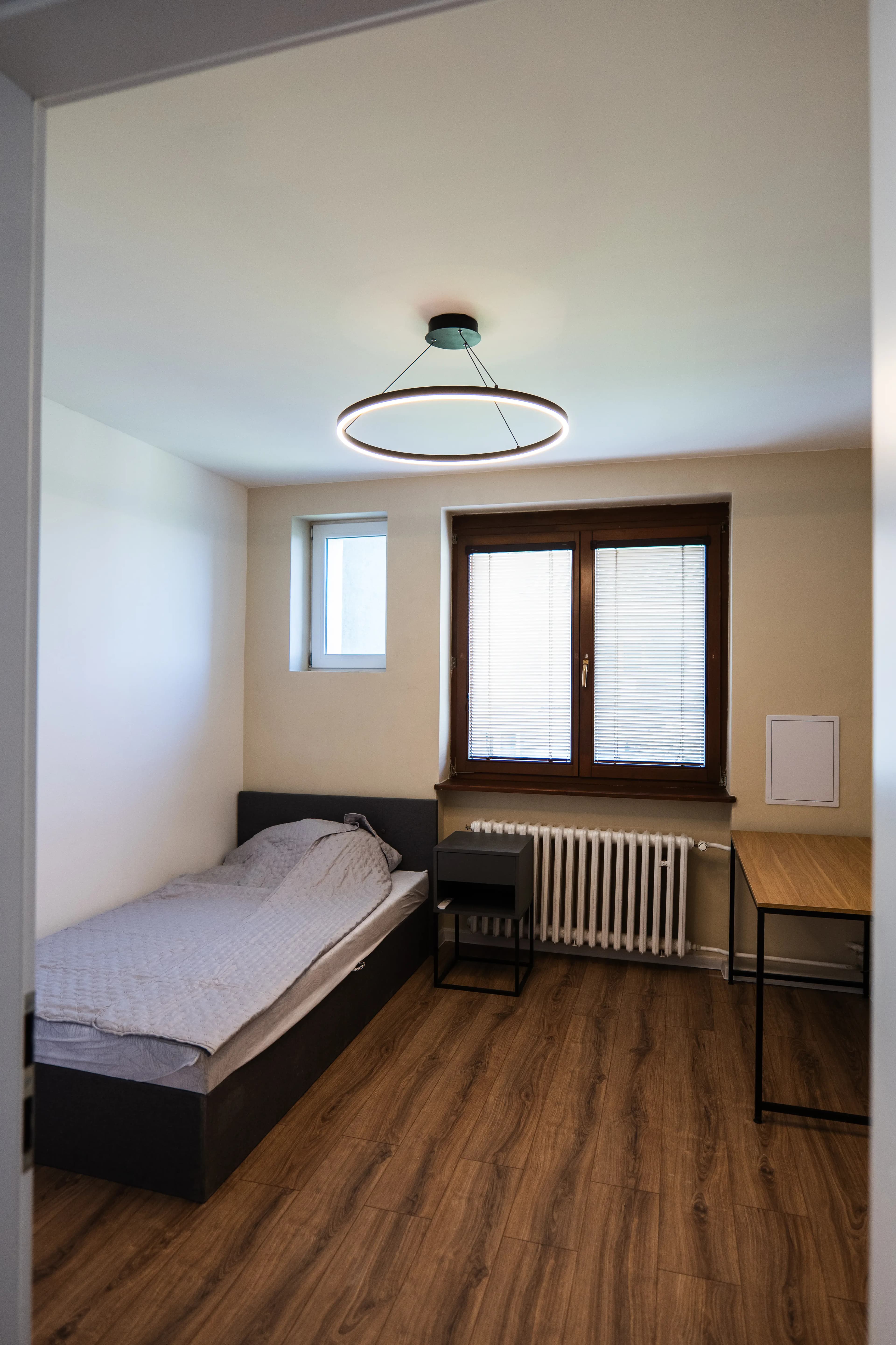 Moderná kancelária v minimalistickom štýle s elegantnými pracovnými stolmi a prírodnými materiálmi.