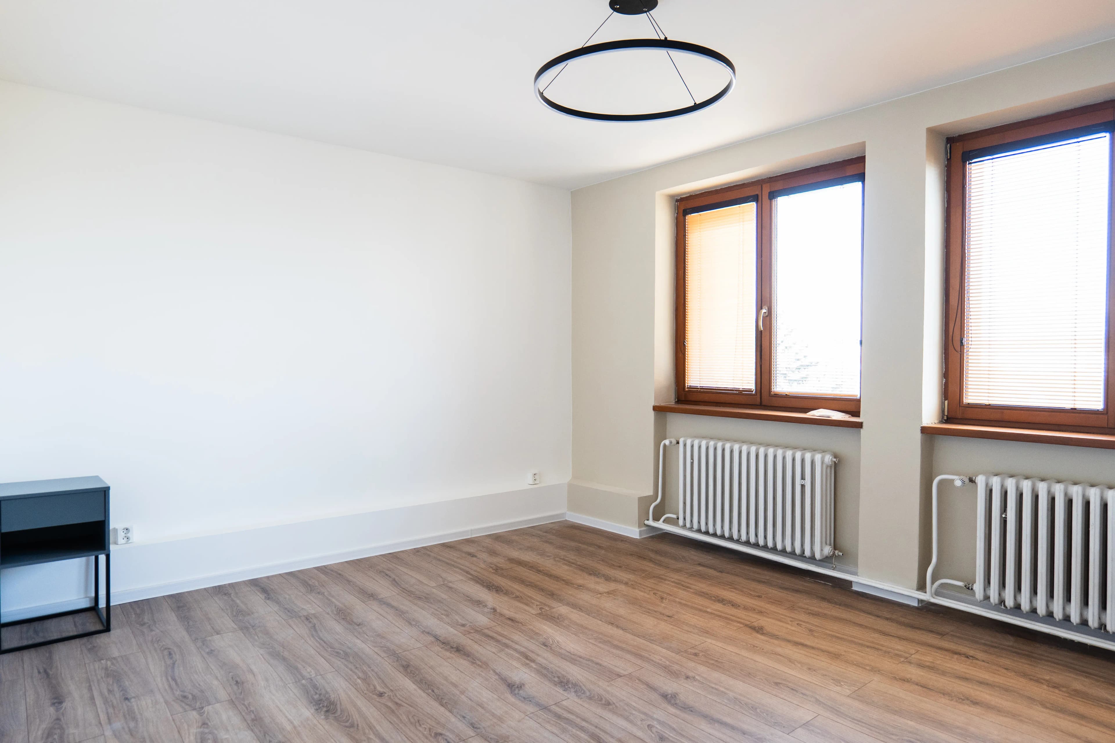 Moderná kancelária v minimalistickom štýle s elegantnými pracovnými stolmi a prírodnými materiálmi.