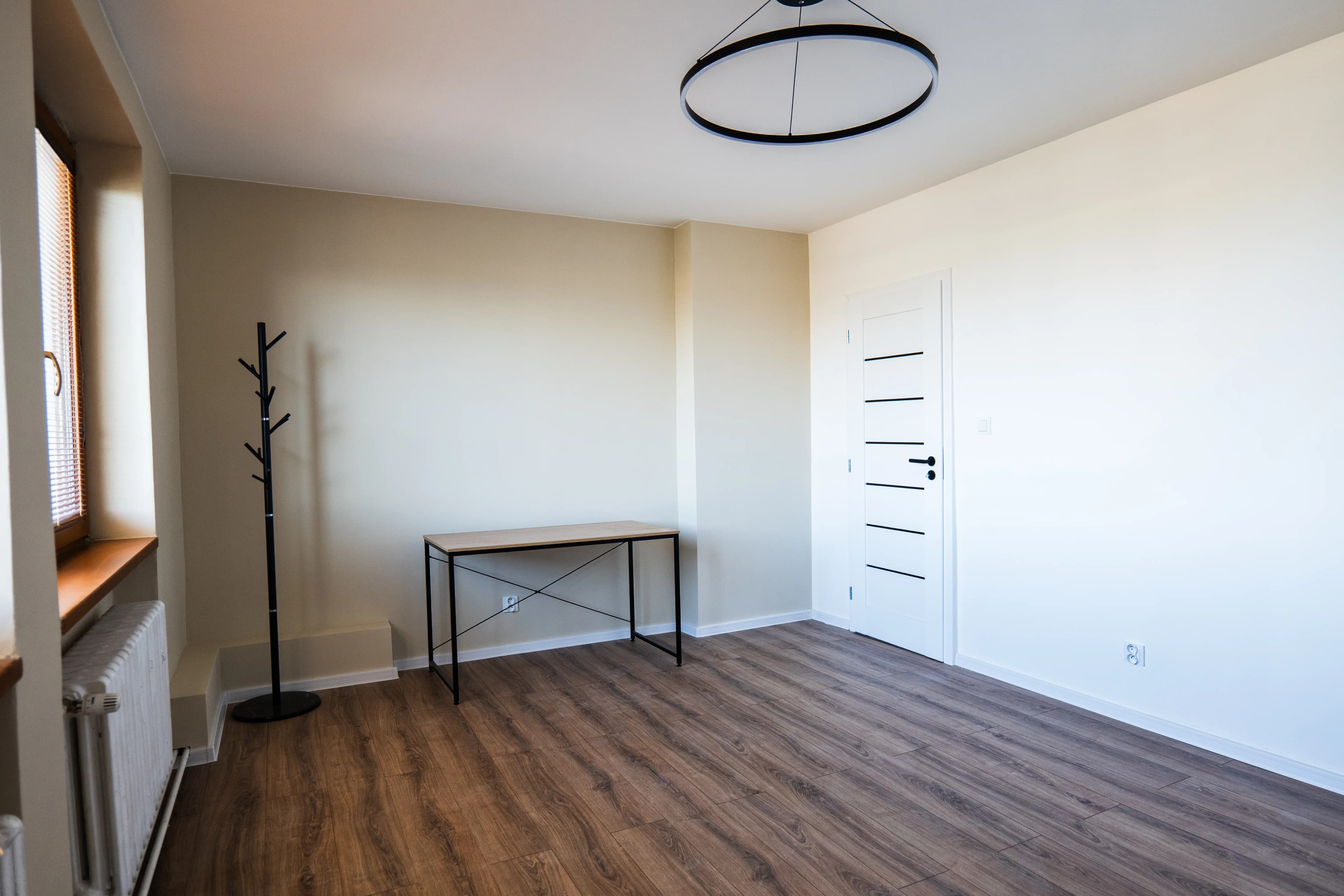 Moderná kancelária v minimalistickom štýle s elegantnými pracovnými stolmi a prírodnými materiálmi.