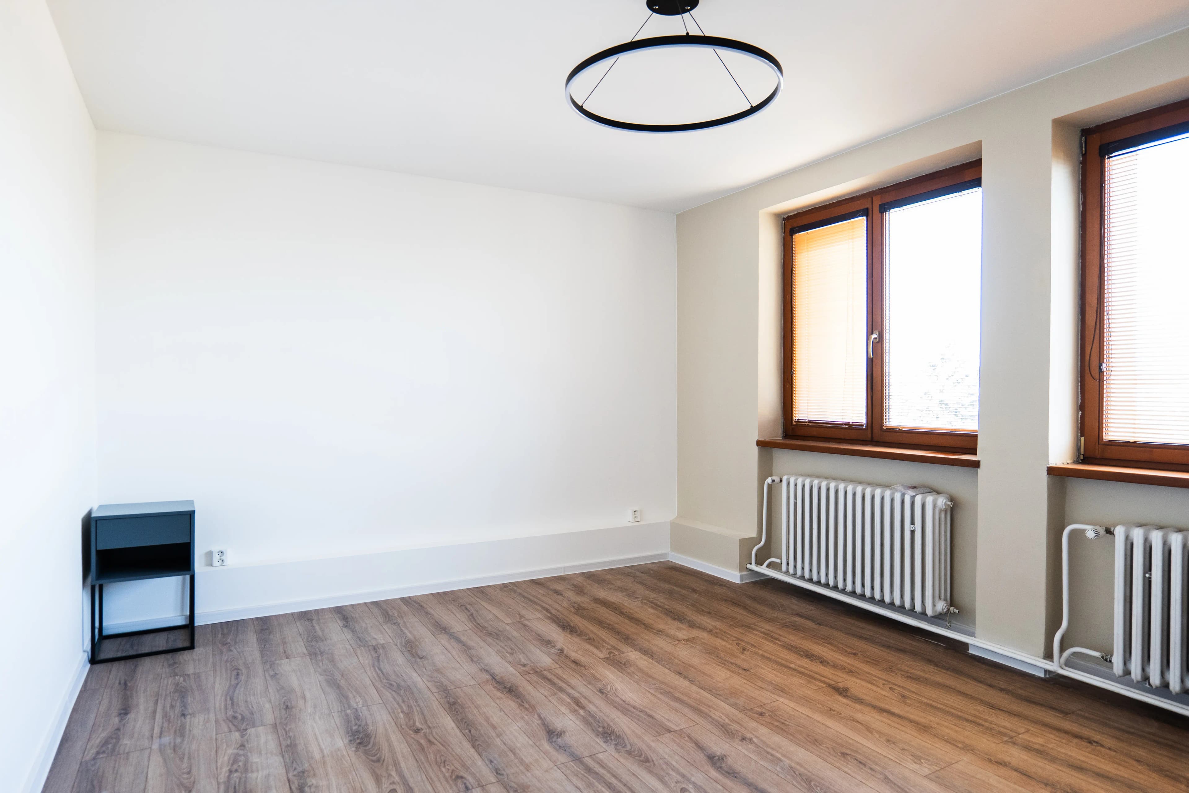 Moderná kancelária v minimalistickom štýle s elegantnými pracovnými stolmi a prírodnými materiálmi.