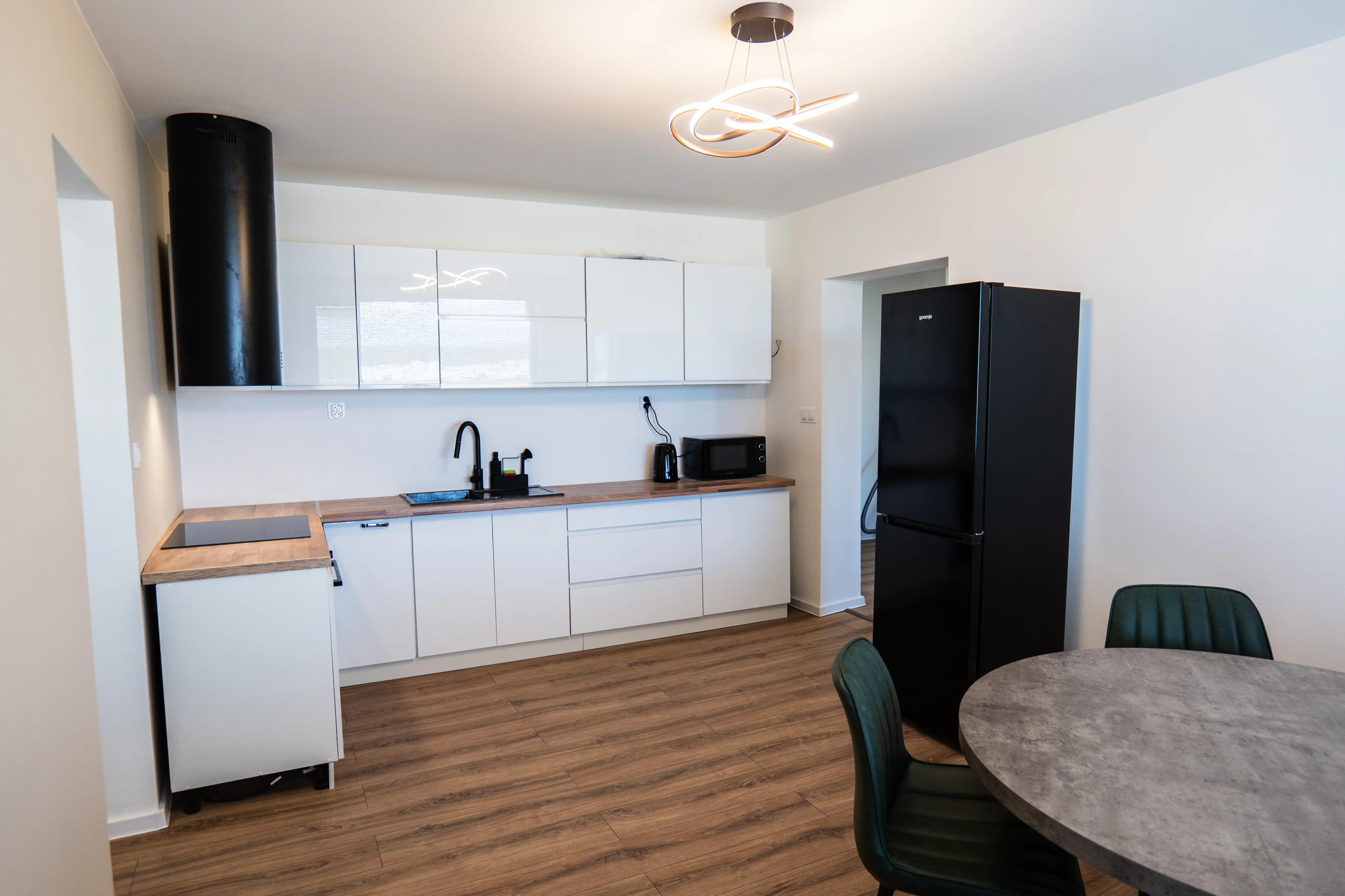 Moderná kancelária v minimalistickom štýle s elegantnými pracovnými stolmi a prírodnými materiálmi.