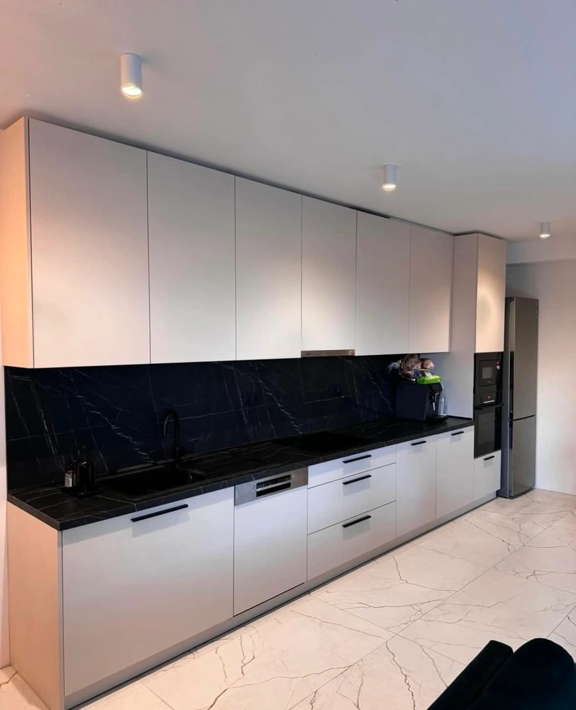 Svetlá moderná obývačka s veľkými presklenými stenami, neutrálnou farebnou paletou, štýlovým nábytkom a elegantným osvetlením.