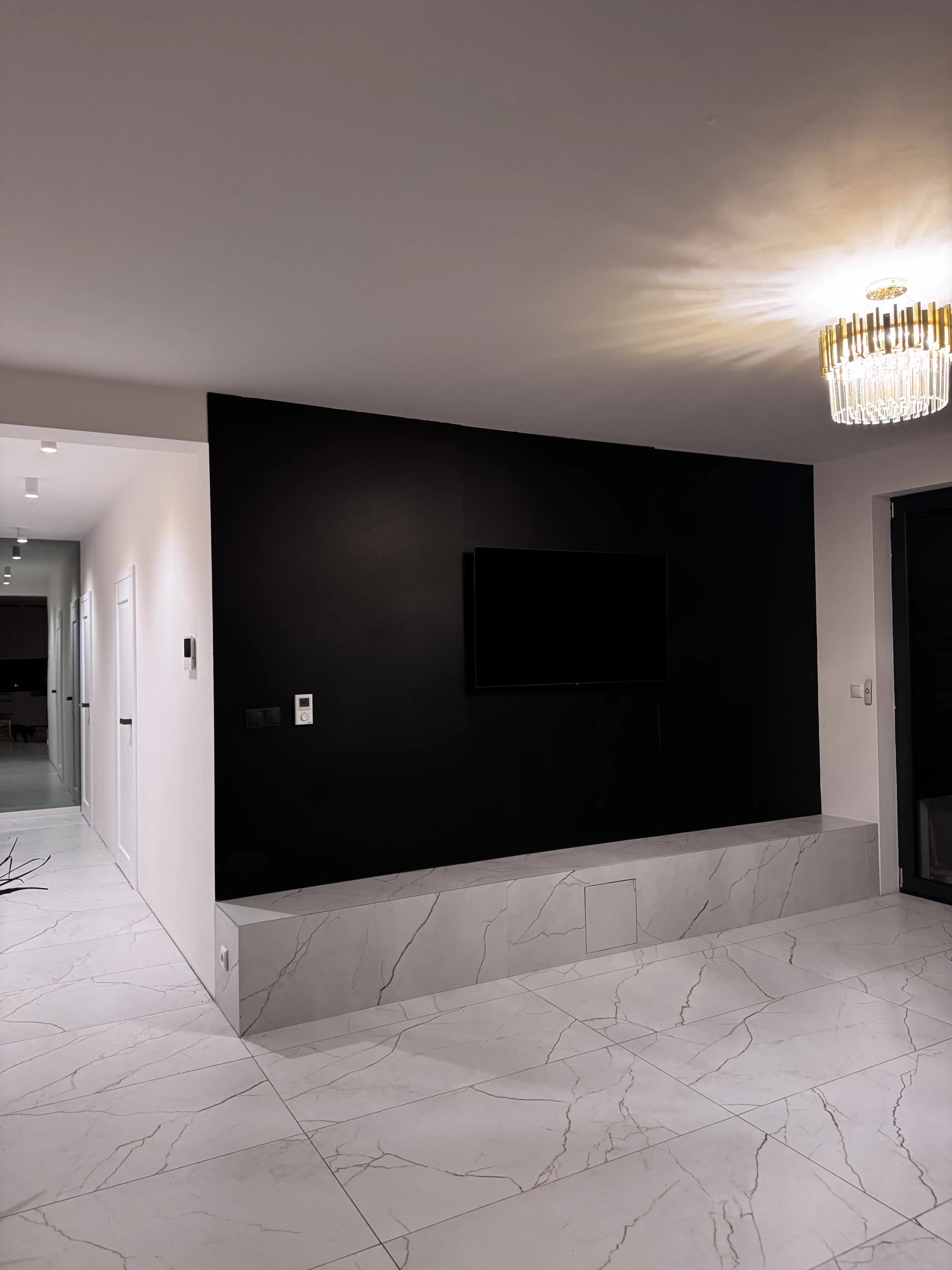 Svetlá moderná obývačka s veľkými presklenými stenami, neutrálnou farebnou paletou, štýlovým nábytkom a elegantným osvetlením.