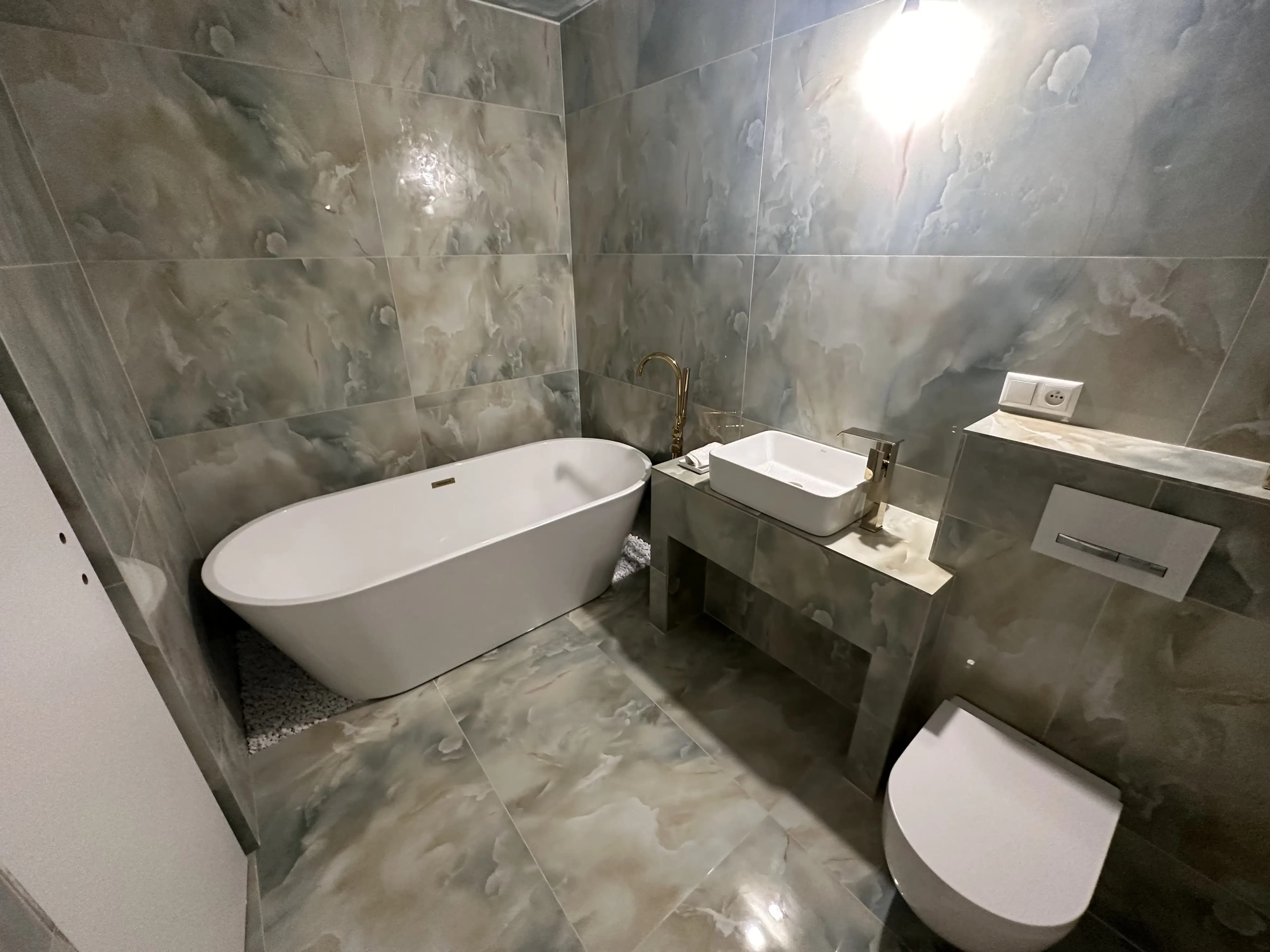 Svetlá moderná obývačka s veľkými presklenými stenami, neutrálnou farebnou paletou, štýlovým nábytkom a elegantným osvetlením.