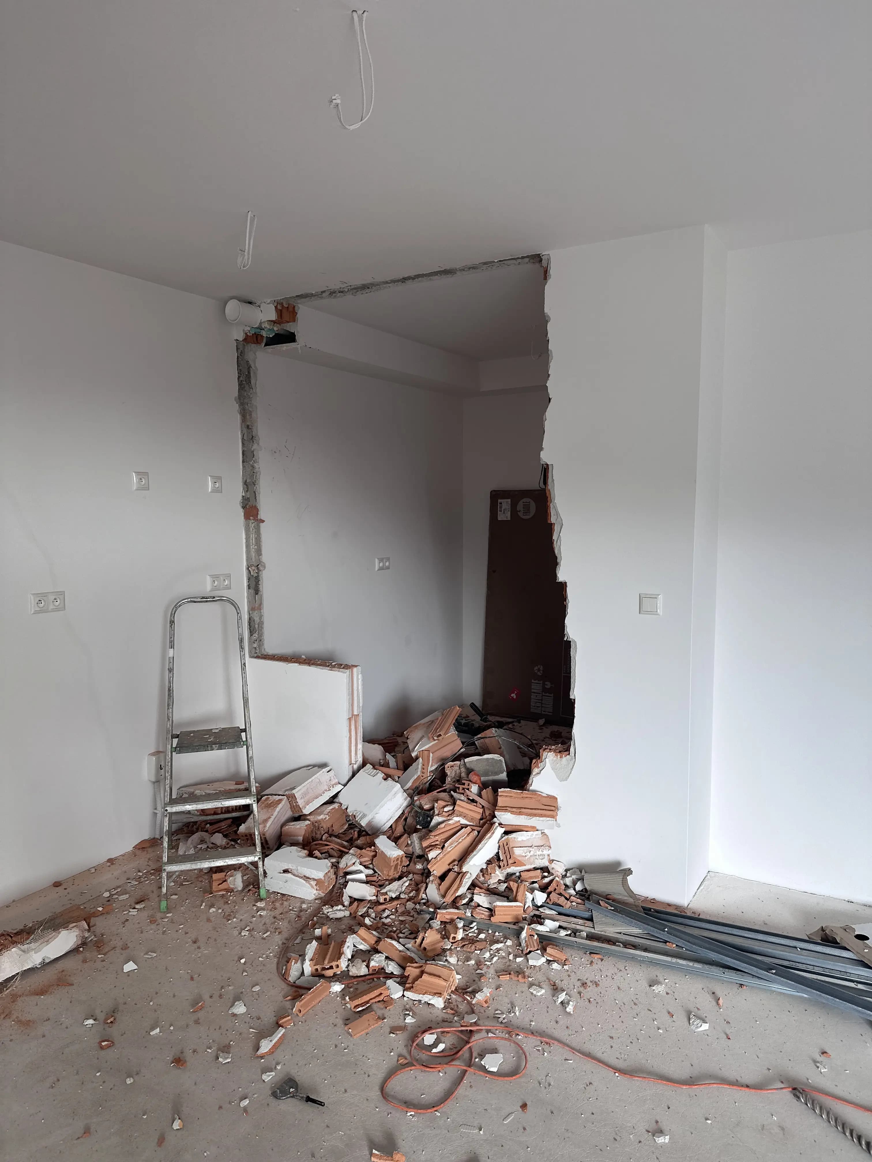 Svetlá moderná obývačka s veľkými presklenými stenami, neutrálnou farebnou paletou, štýlovým nábytkom a elegantným osvetlením.