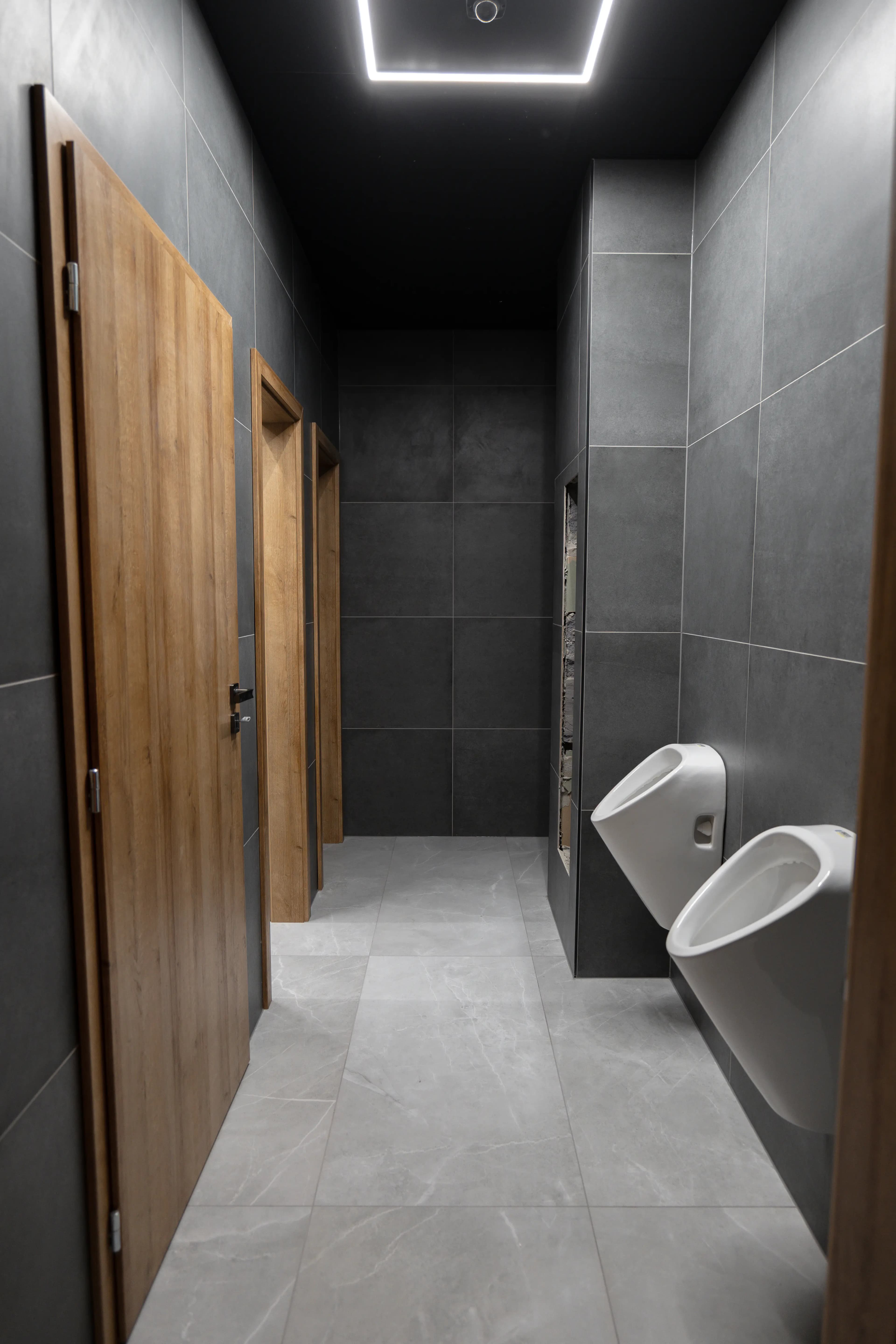 Moderná kancelária v minimalistickom štýle s elegantnými pracovnými stolmi a prírodnými materiálmi.