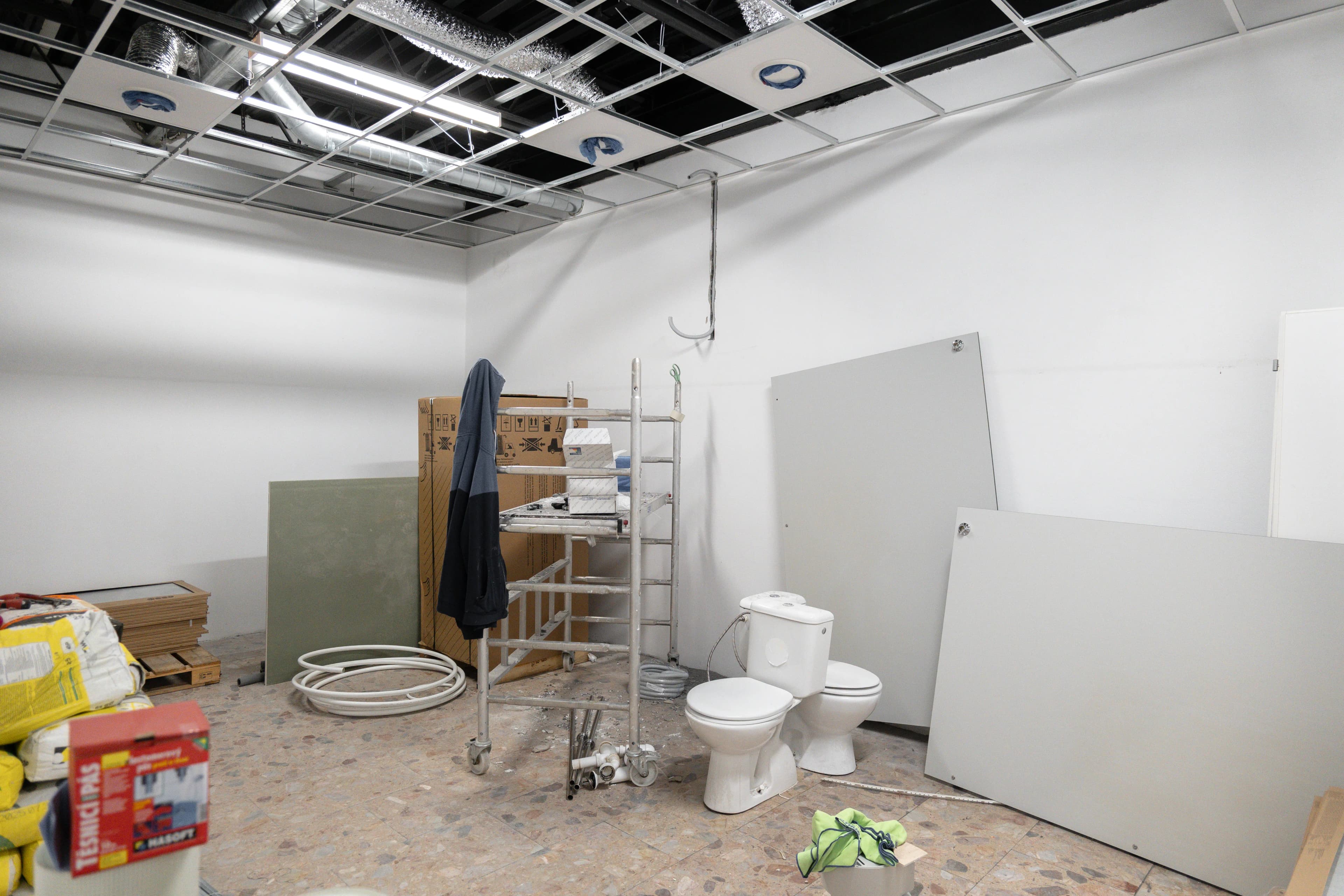 Moderná kancelária v minimalistickom štýle s elegantnými pracovnými stolmi a prírodnými materiálmi.