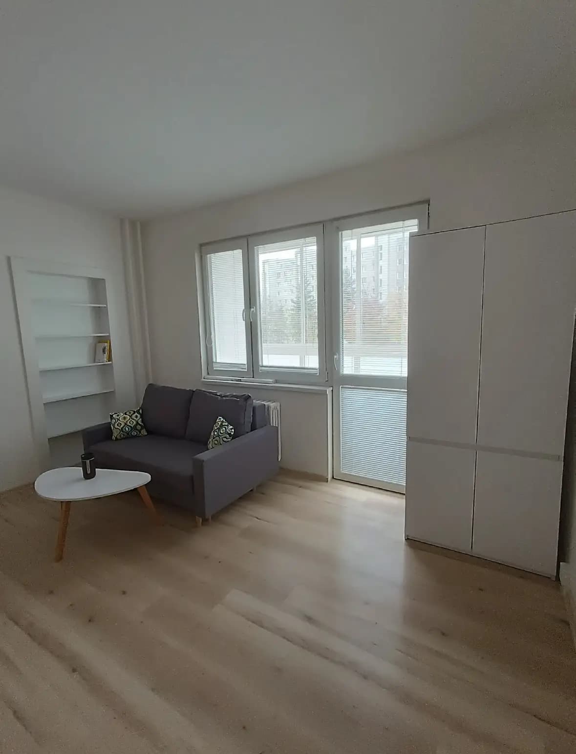 Štýlová tmavá kuchyňa s moderným osvetlením, zlatými akcentmi a elegantným jedálenským stolom.