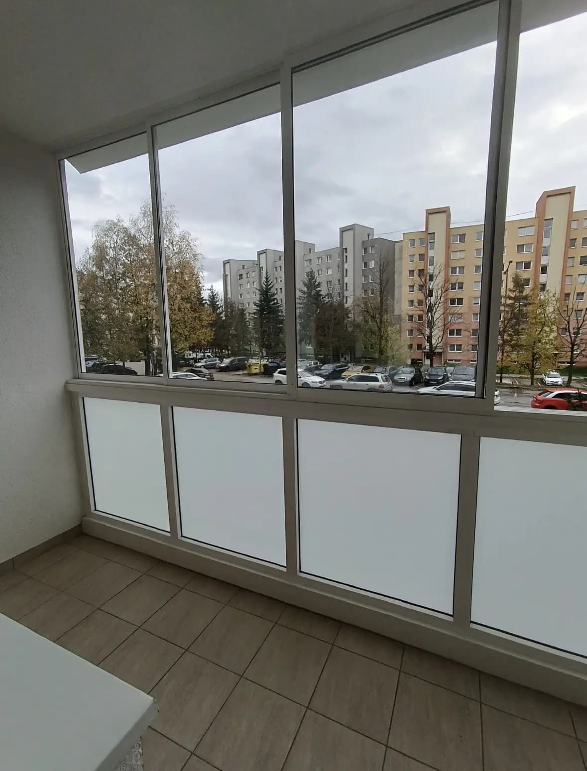 Štýlová tmavá kuchyňa s moderným osvetlením, zlatými akcentmi a elegantným jedálenským stolom.