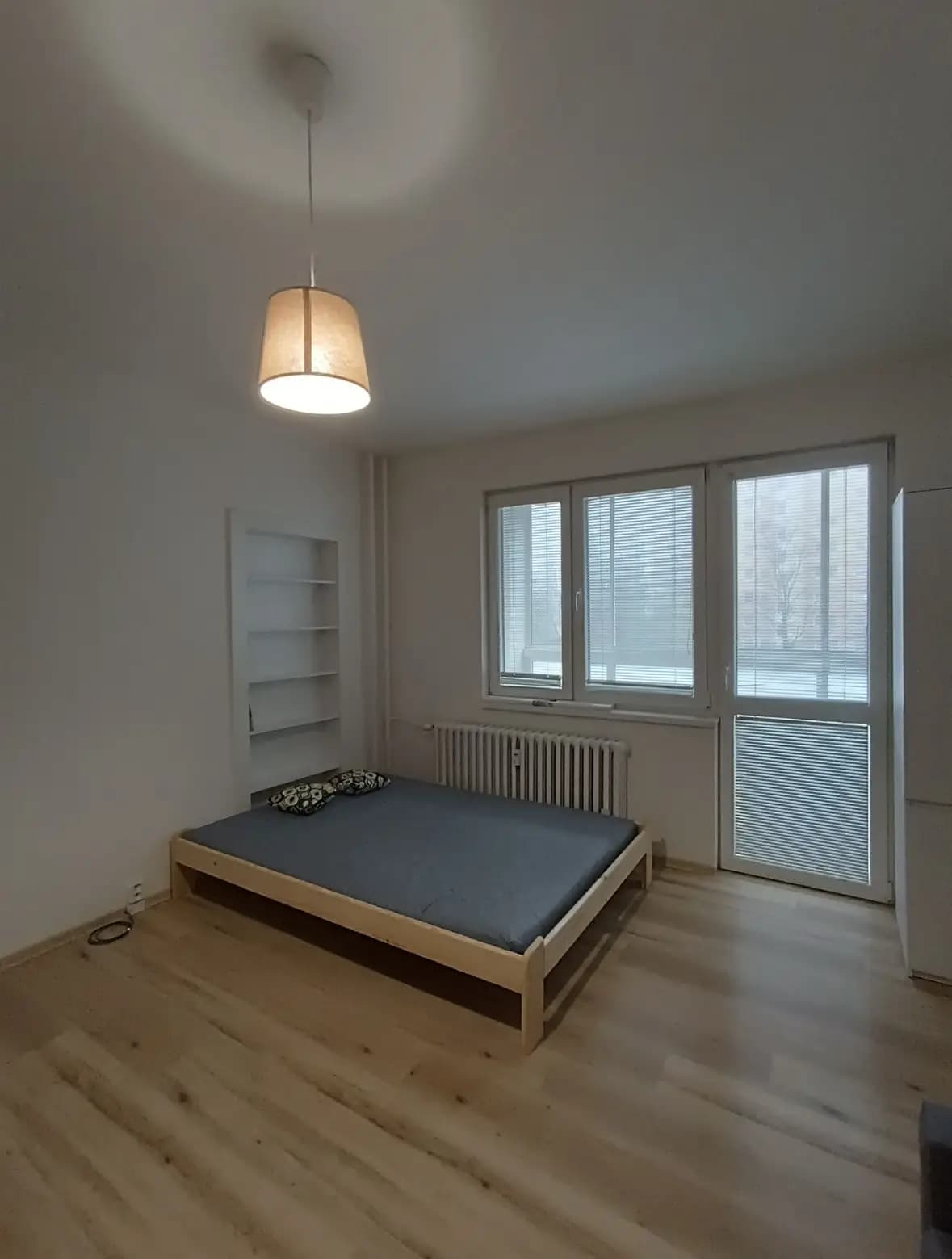 Štýlová tmavá kuchyňa s moderným osvetlením, zlatými akcentmi a elegantným jedálenským stolom.