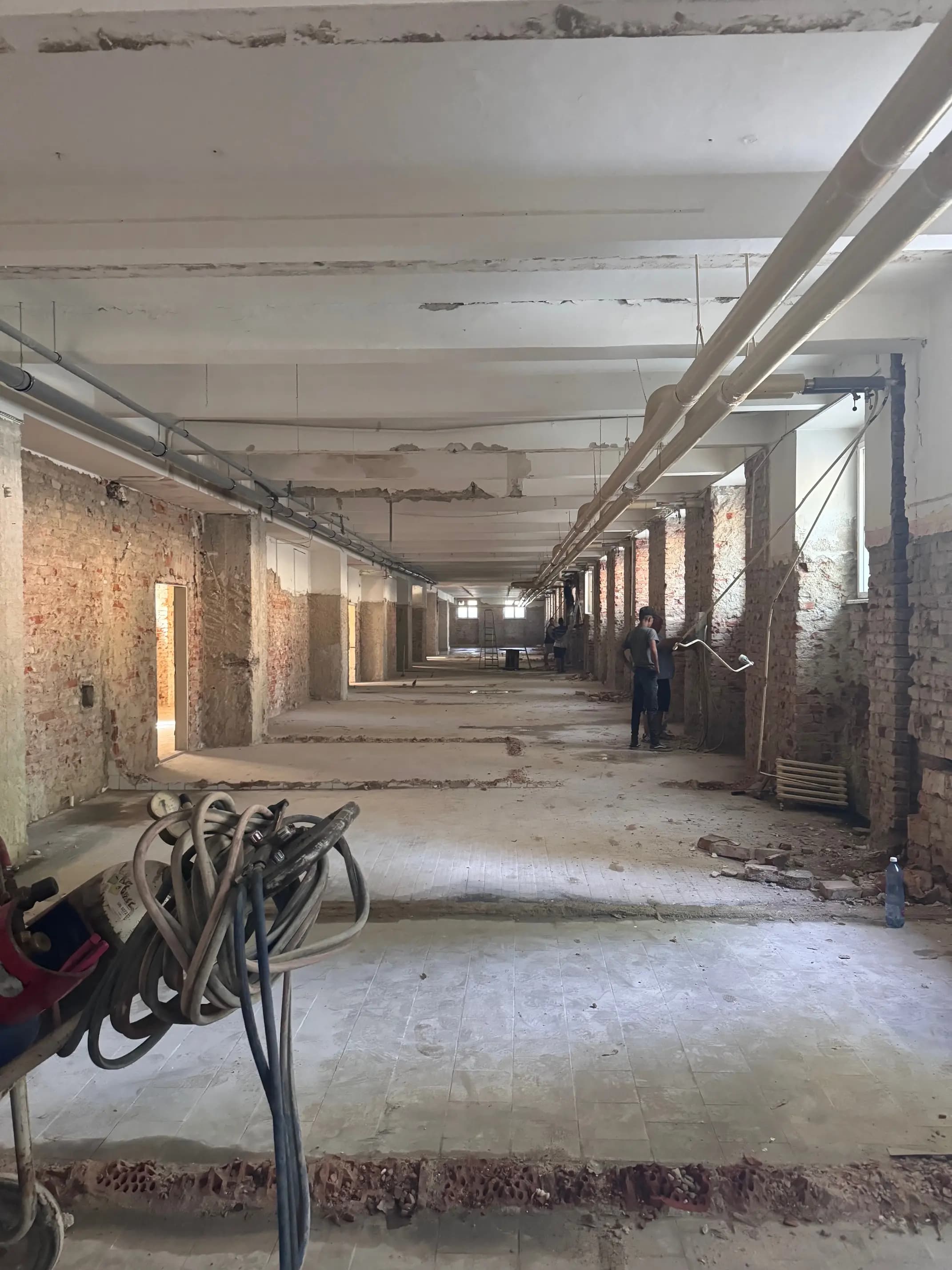 Moderná kancelária v minimalistickom štýle s elegantnými pracovnými stolmi a prírodnými materiálmi.