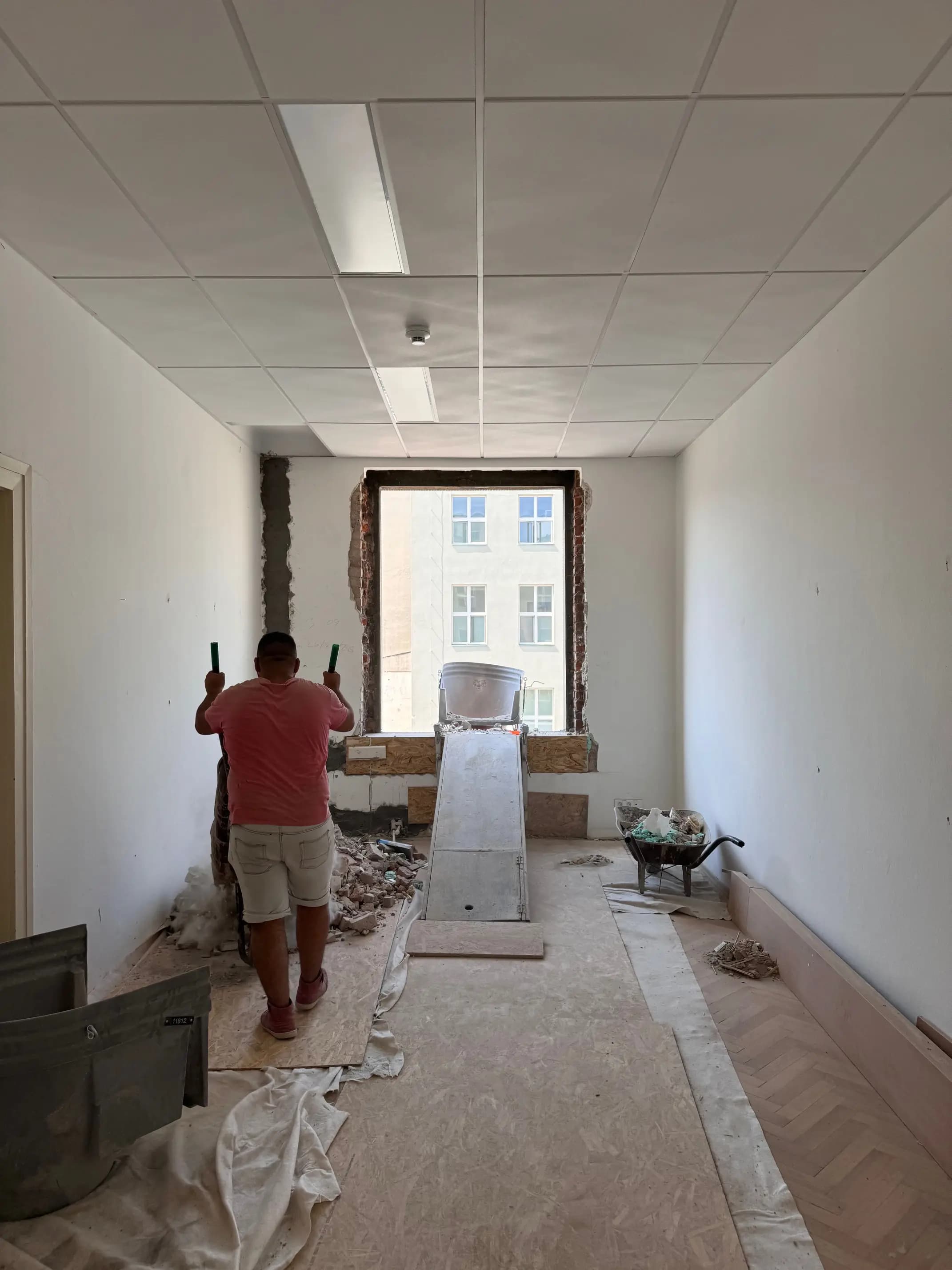 Moderná kancelária v minimalistickom štýle s elegantnými pracovnými stolmi a prírodnými materiálmi.