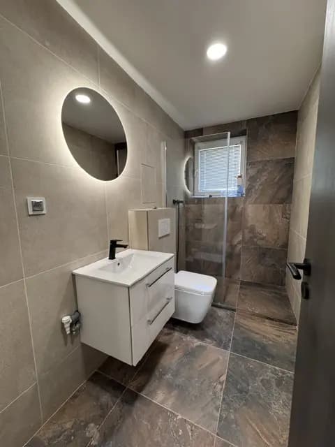 Moderná kancelária v minimalistickom štýle s elegantnými pracovnými stolmi a prírodnými materiálmi.