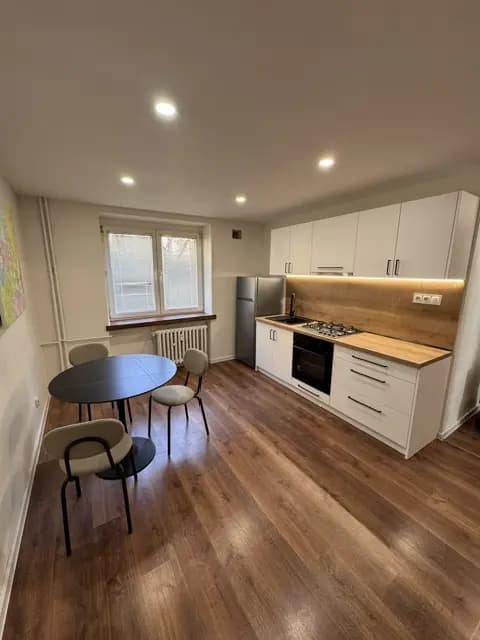 Moderná kancelária v minimalistickom štýle s elegantnými pracovnými stolmi a prírodnými materiálmi.