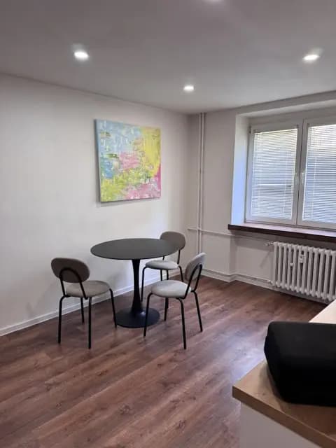 Moderná kancelária v minimalistickom štýle s elegantnými pracovnými stolmi a prírodnými materiálmi.