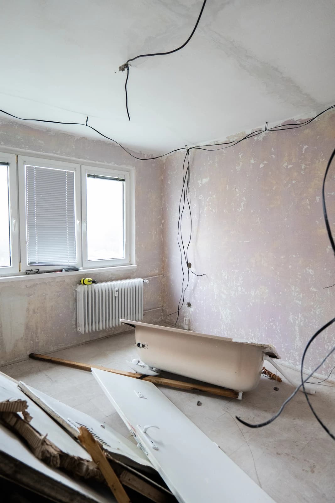 Štýlová tmavá kuchyňa s moderným osvetlením, zlatými akcentmi a elegantným jedálenským stolom.