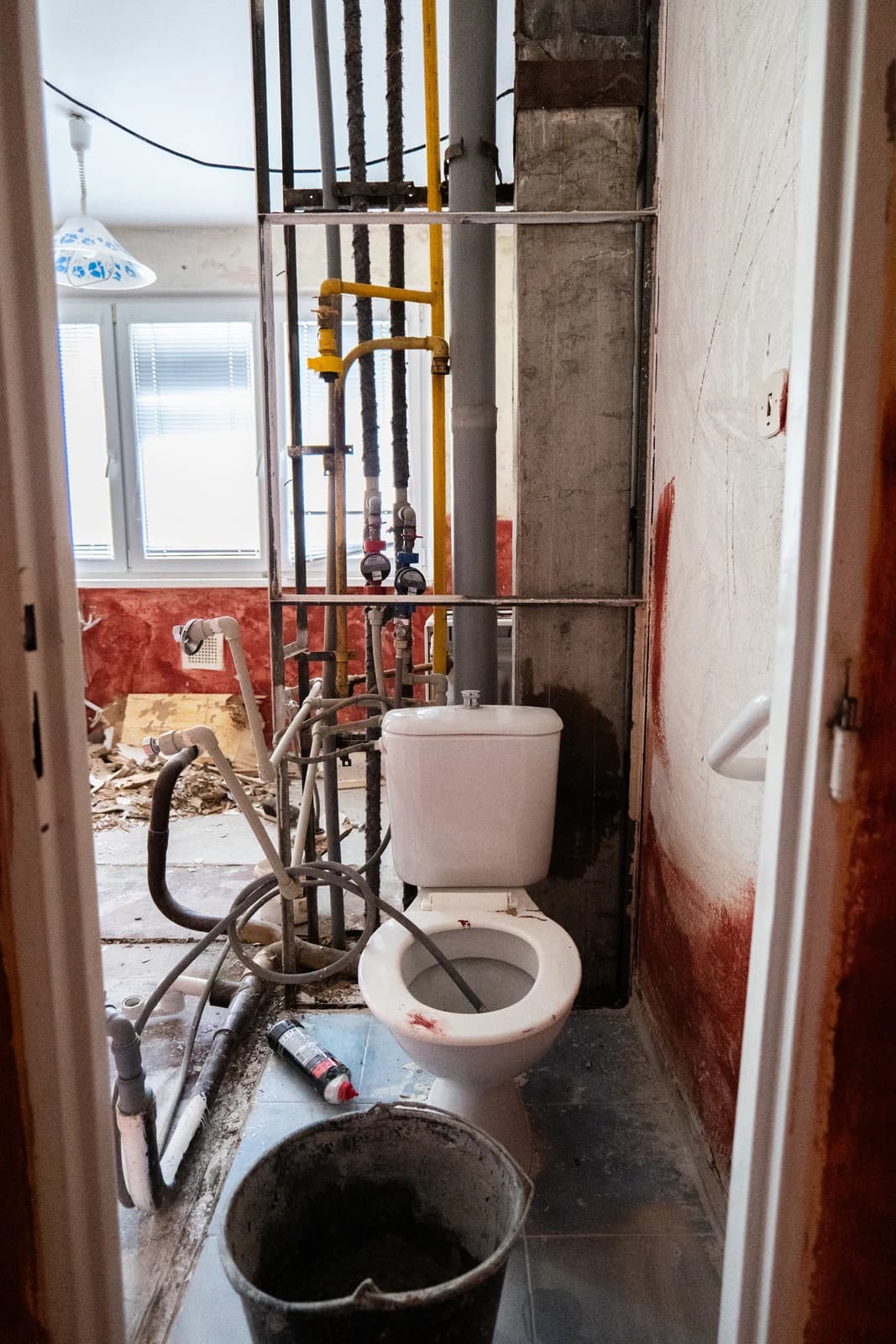 Štýlová tmavá kuchyňa s moderným osvetlením, zlatými akcentmi a elegantným jedálenským stolom.