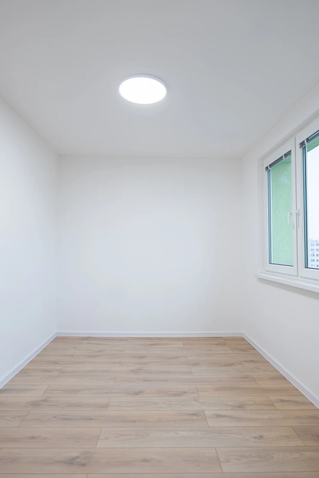 Štýlová tmavá kuchyňa s moderným osvetlením, zlatými akcentmi a elegantným jedálenským stolom.