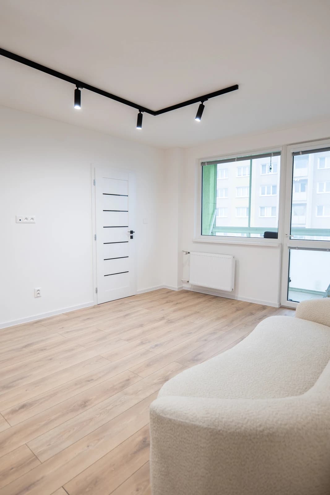 Štýlová tmavá kuchyňa s moderným osvetlením, zlatými akcentmi a elegantným jedálenským stolom.