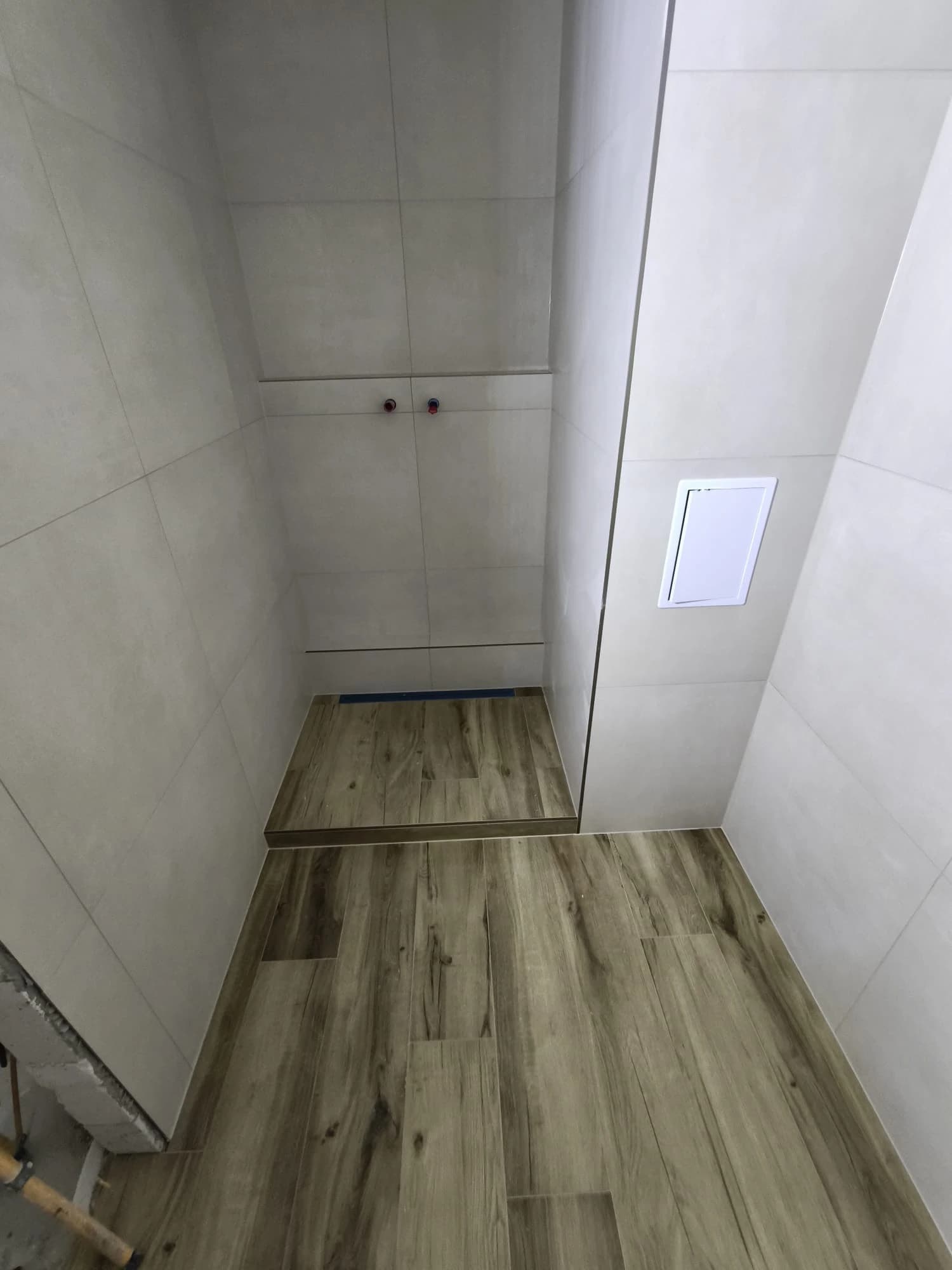 Štýlová tmavá kuchyňa s moderným osvetlením, zlatými akcentmi a elegantným jedálenským stolom.