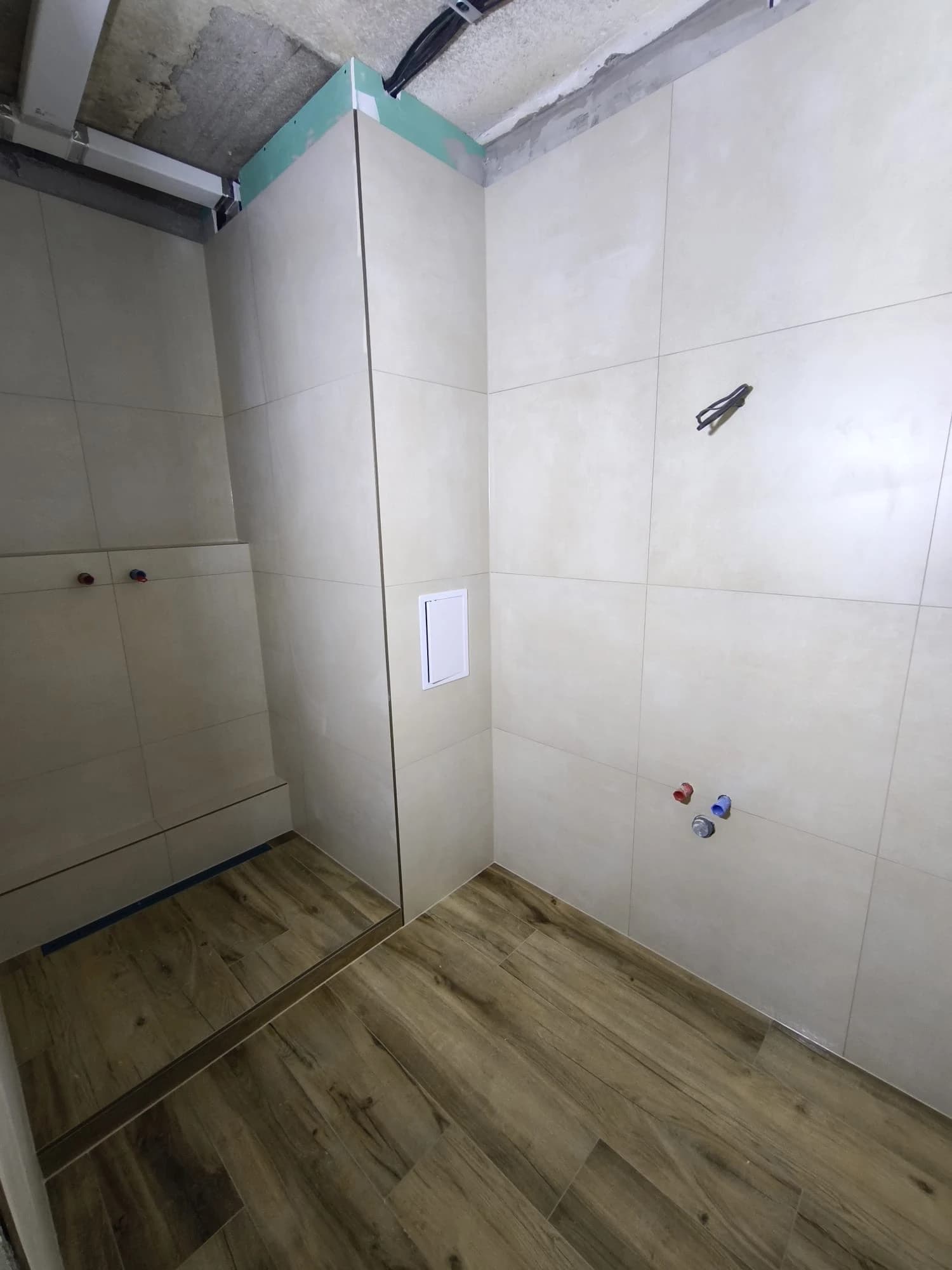 Štýlová tmavá kuchyňa s moderným osvetlením, zlatými akcentmi a elegantným jedálenským stolom.