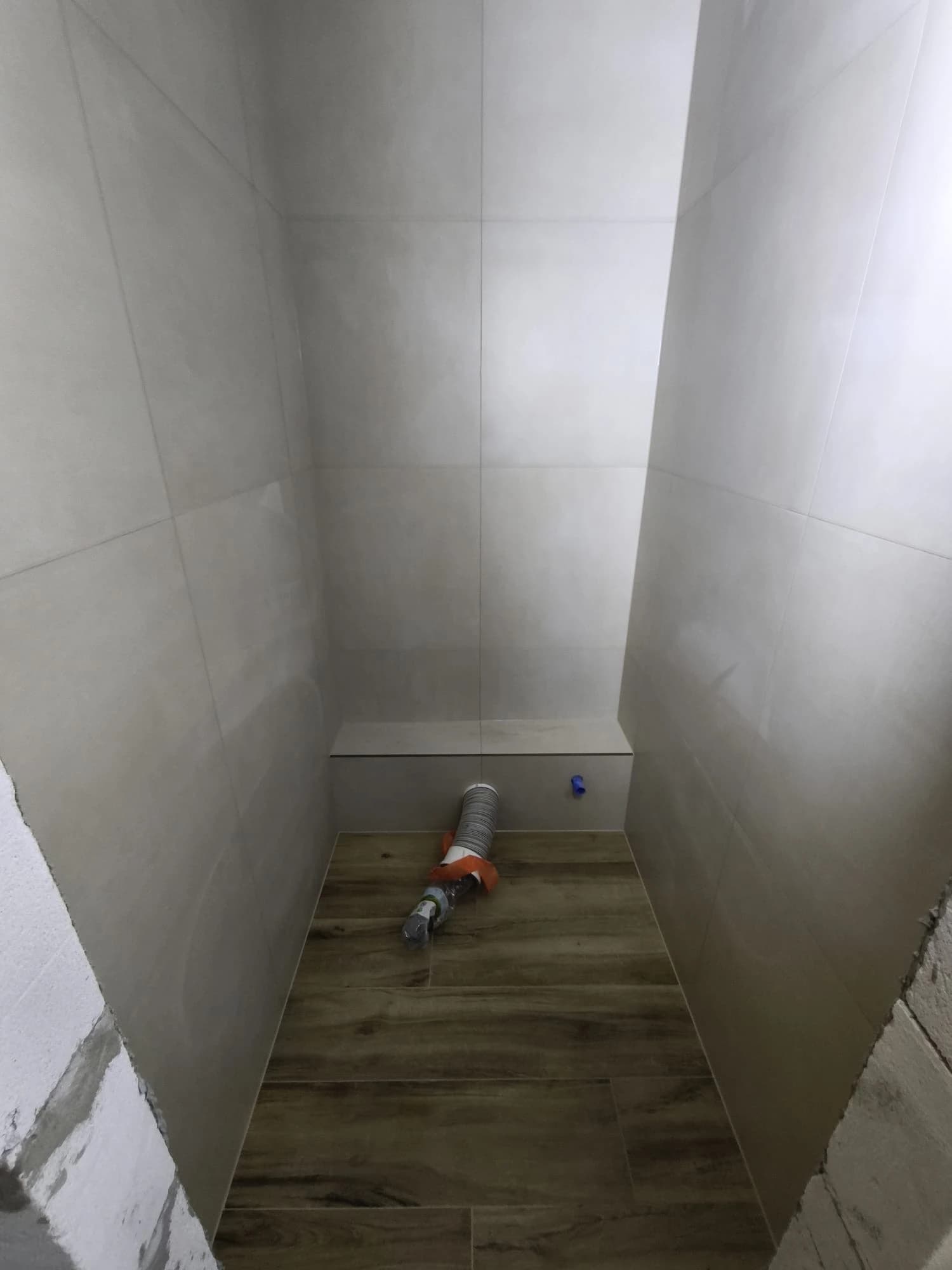 Štýlová tmavá kuchyňa s moderným osvetlením, zlatými akcentmi a elegantným jedálenským stolom.