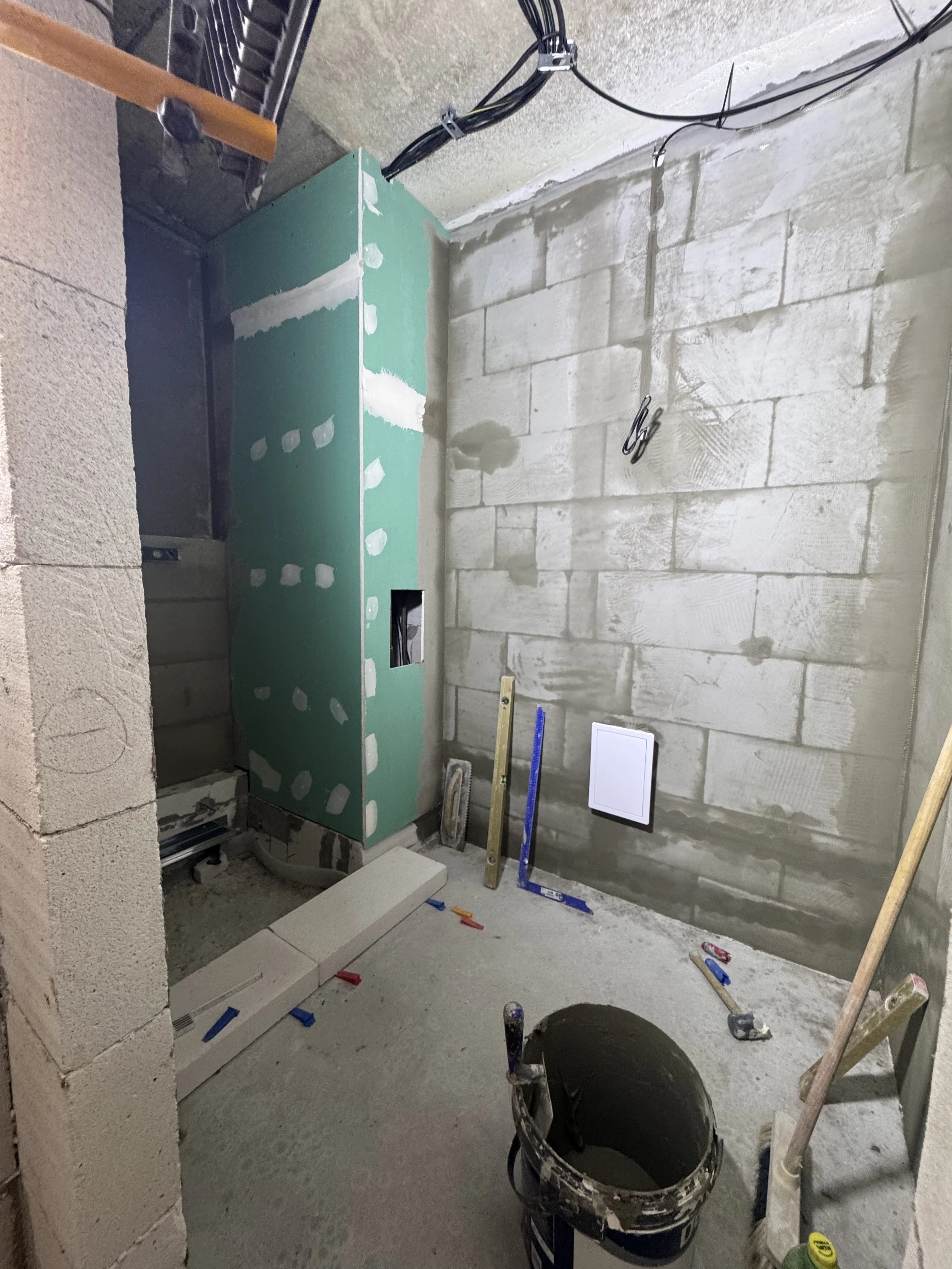 Štýlová tmavá kuchyňa s moderným osvetlením, zlatými akcentmi a elegantným jedálenským stolom.