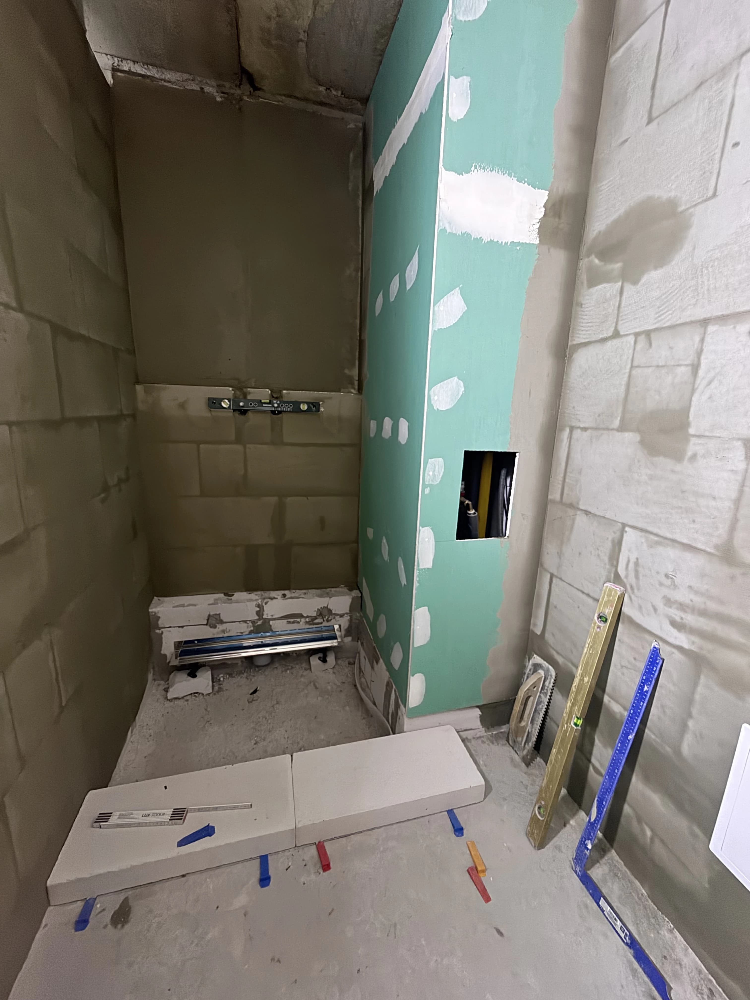 Štýlová tmavá kuchyňa s moderným osvetlením, zlatými akcentmi a elegantným jedálenským stolom.