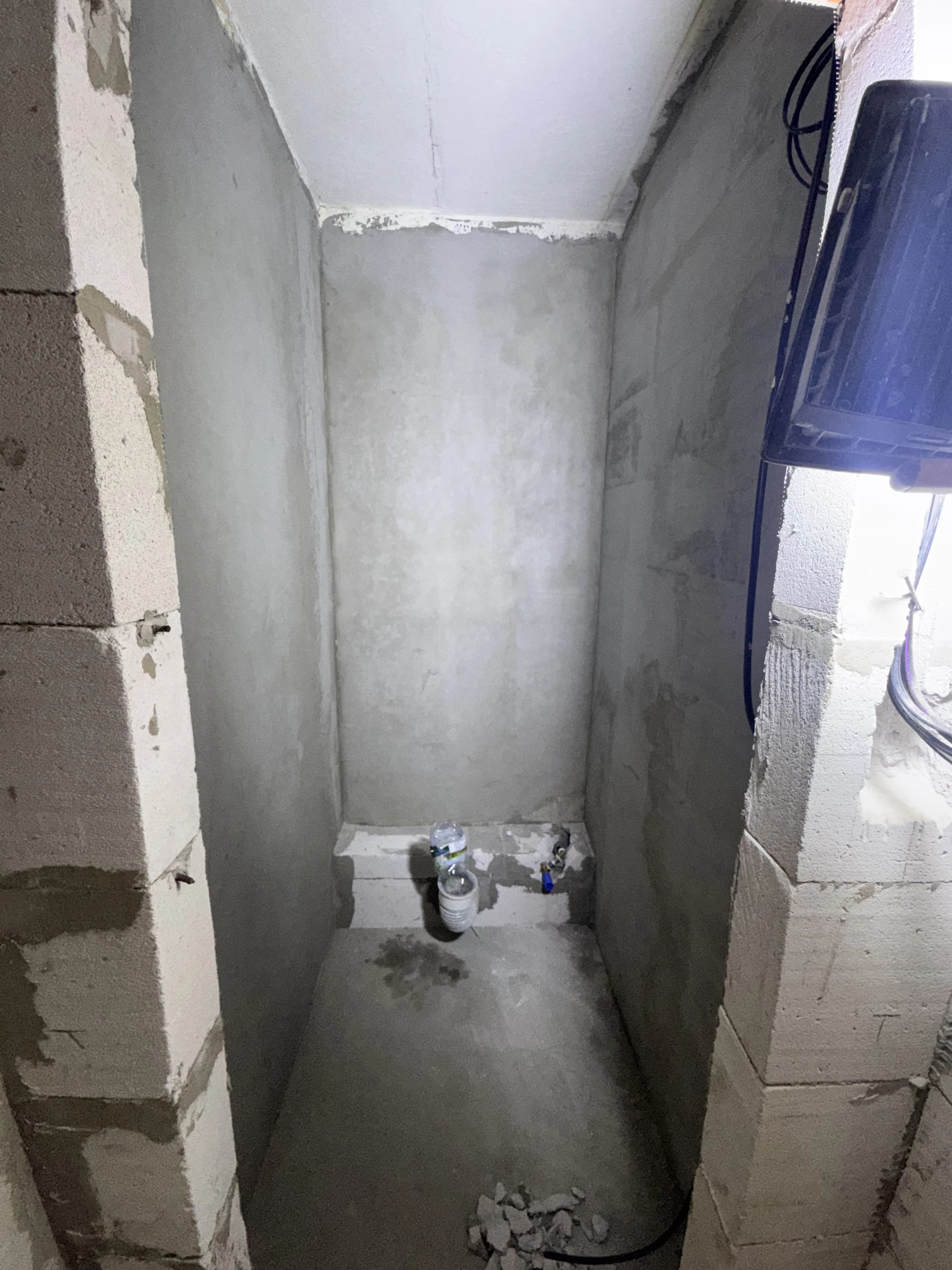 Štýlová tmavá kuchyňa s moderným osvetlením, zlatými akcentmi a elegantným jedálenským stolom.