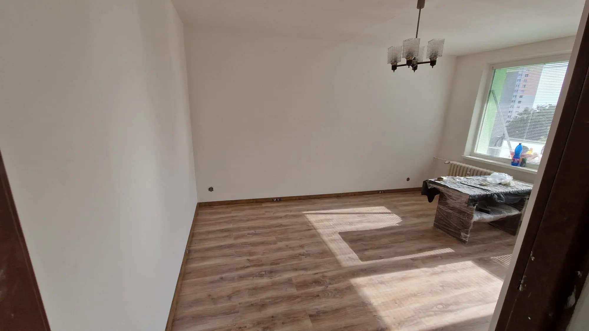 Moderná kancelária v minimalistickom štýle s elegantnými pracovnými stolmi a prírodnými materiálmi.