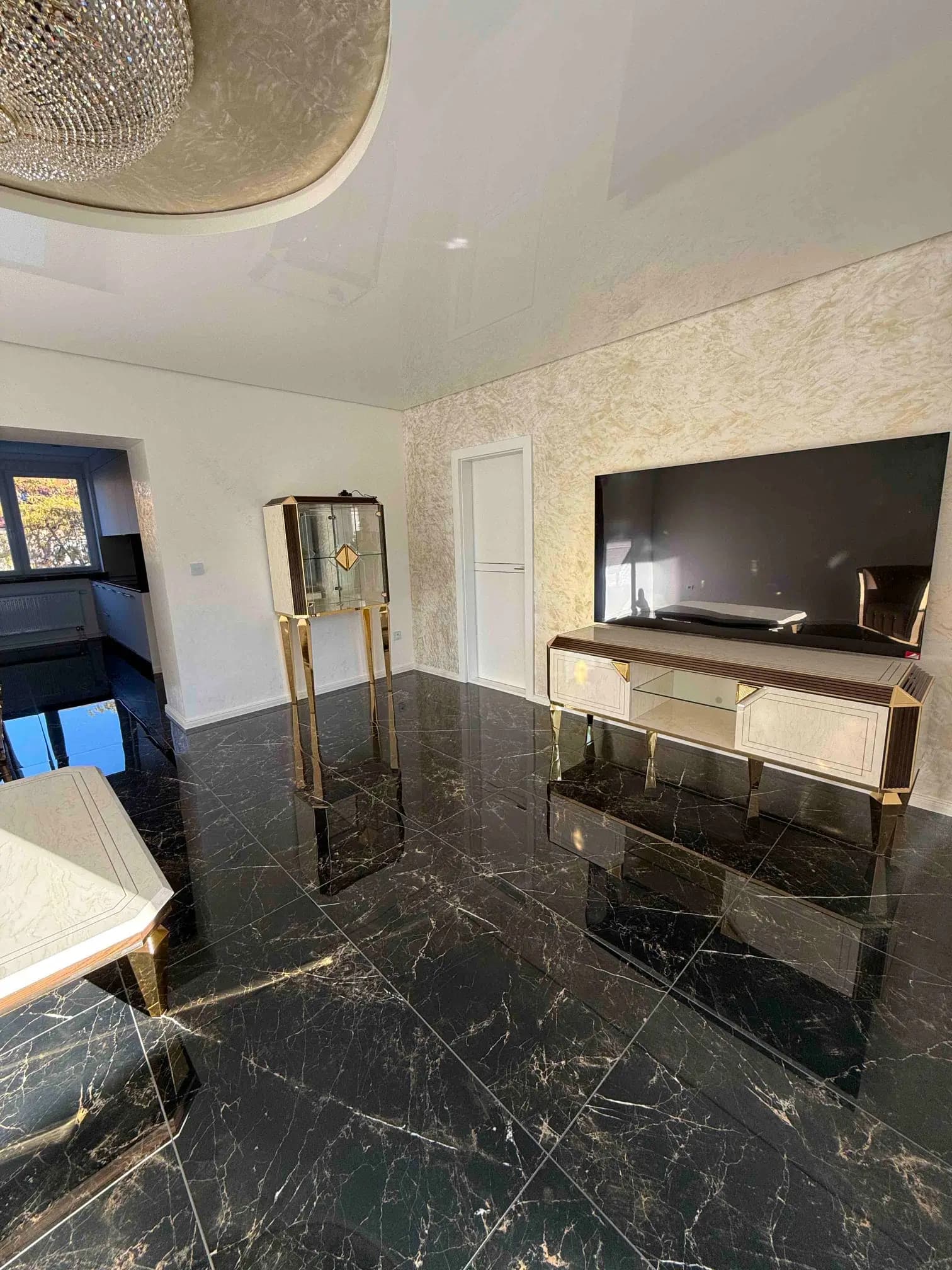 Elegantný interiér vily s veľkolepým visiacim lustrom, moderným dizajnom a otvoreným dvojpodlažným priestorom.