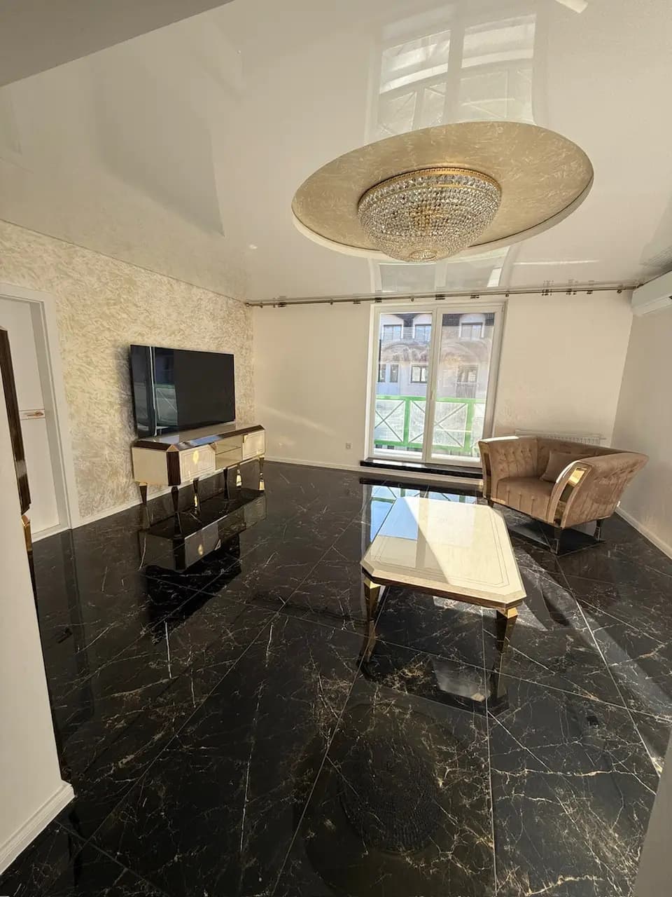 Elegantný interiér vily s veľkolepým visiacim lustrom, moderným dizajnom a otvoreným dvojpodlažným priestorom.