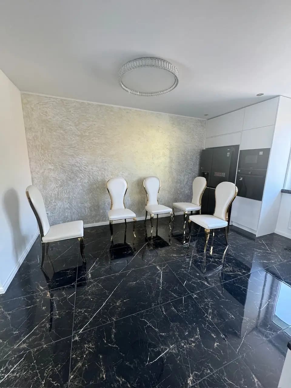 Elegantný interiér vily s veľkolepým visiacim lustrom, moderným dizajnom a otvoreným dvojpodlažným priestorom.