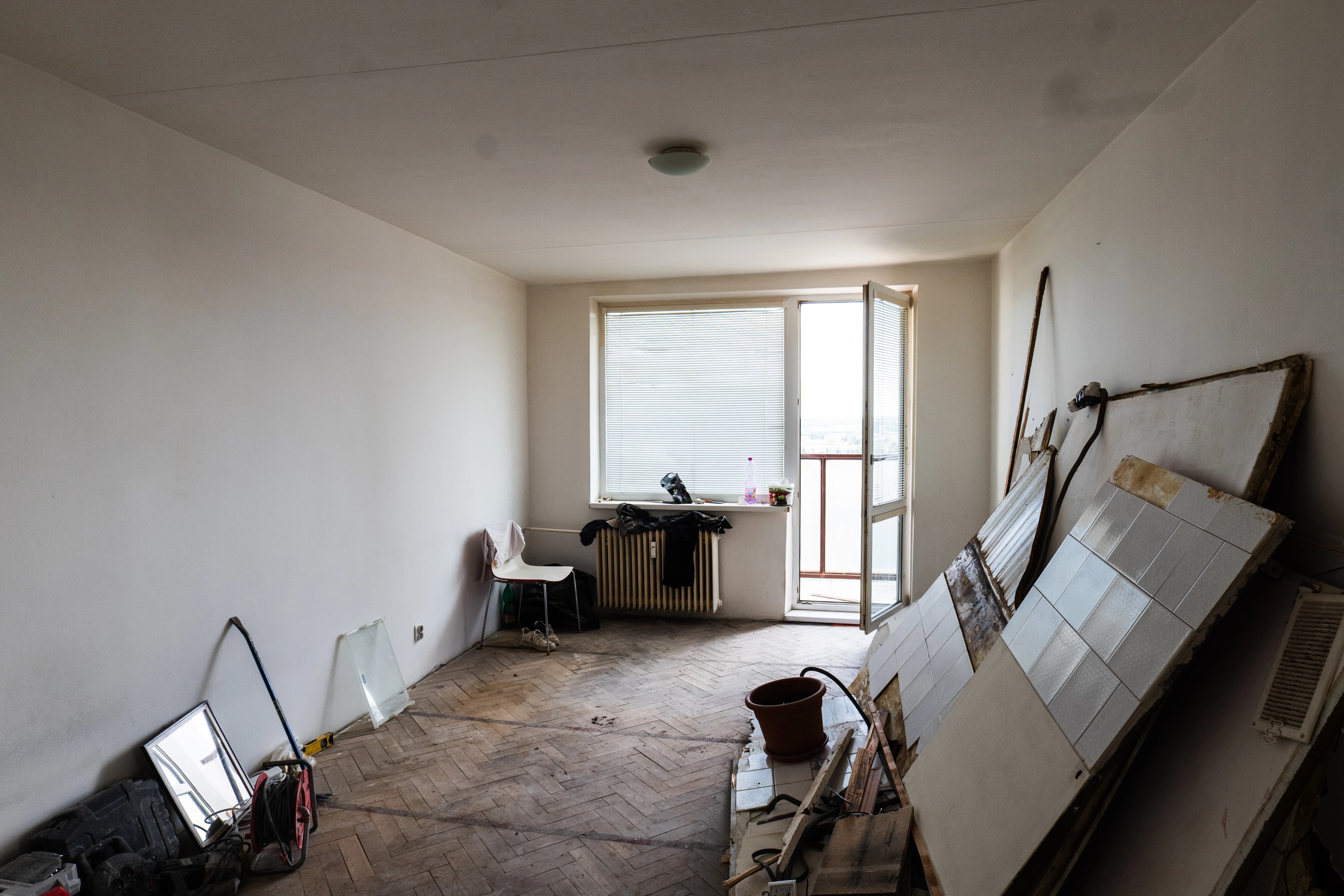 Štýlová tmavá kuchyňa s moderným osvetlením, zlatými akcentmi a elegantným jedálenským stolom.