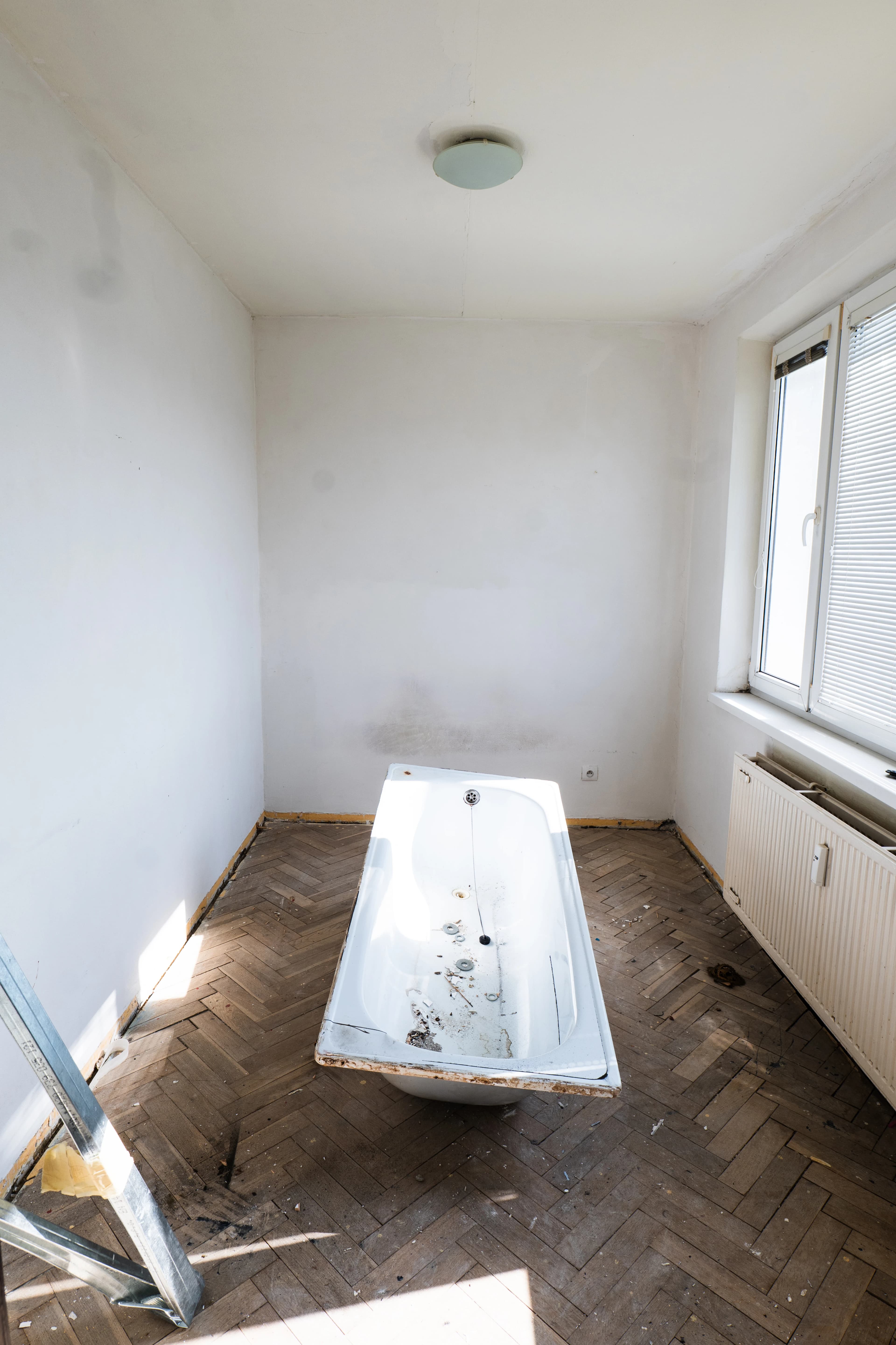 Štýlová tmavá kuchyňa s moderným osvetlením, zlatými akcentmi a elegantným jedálenským stolom.