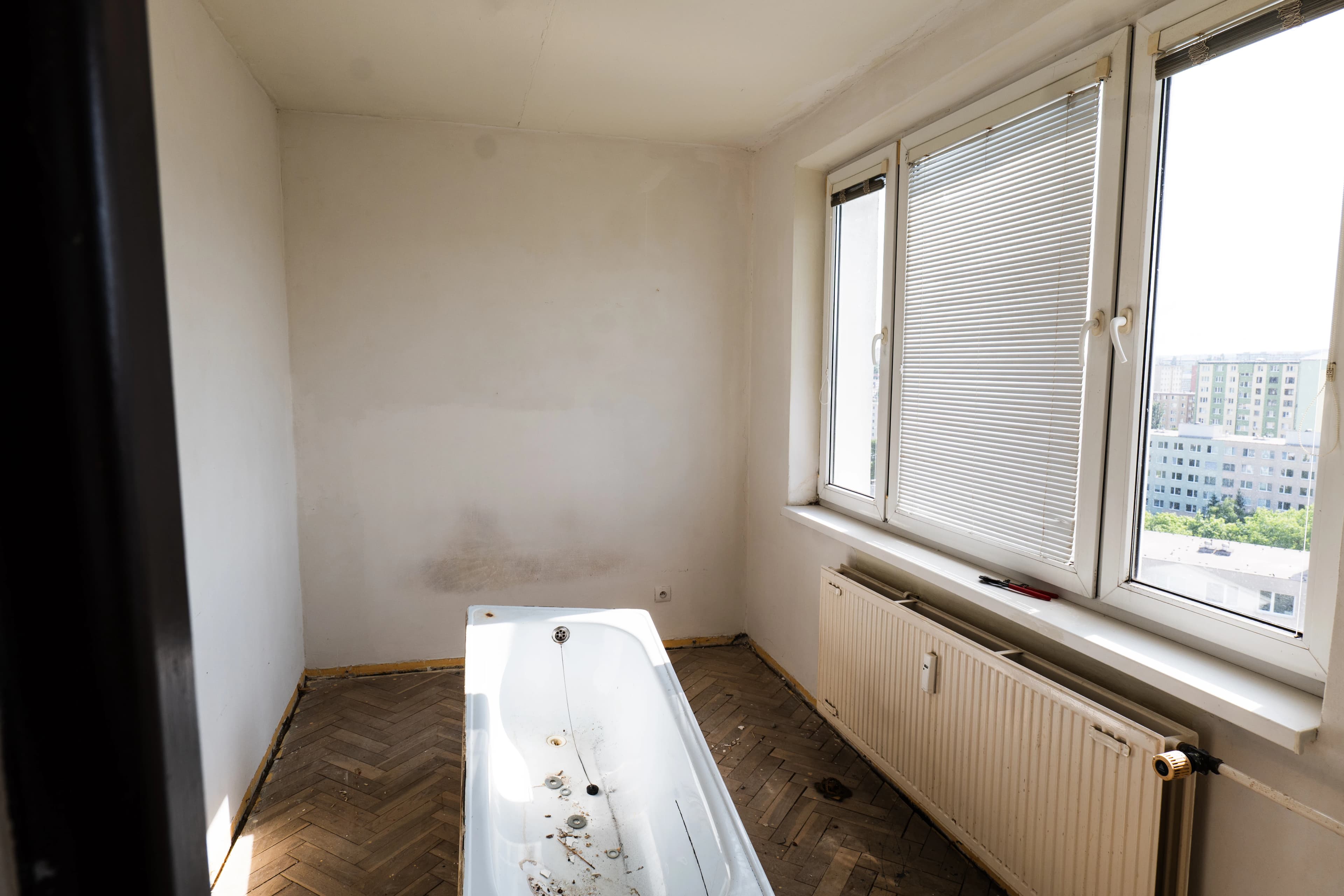 Štýlová tmavá kuchyňa s moderným osvetlením, zlatými akcentmi a elegantným jedálenským stolom.