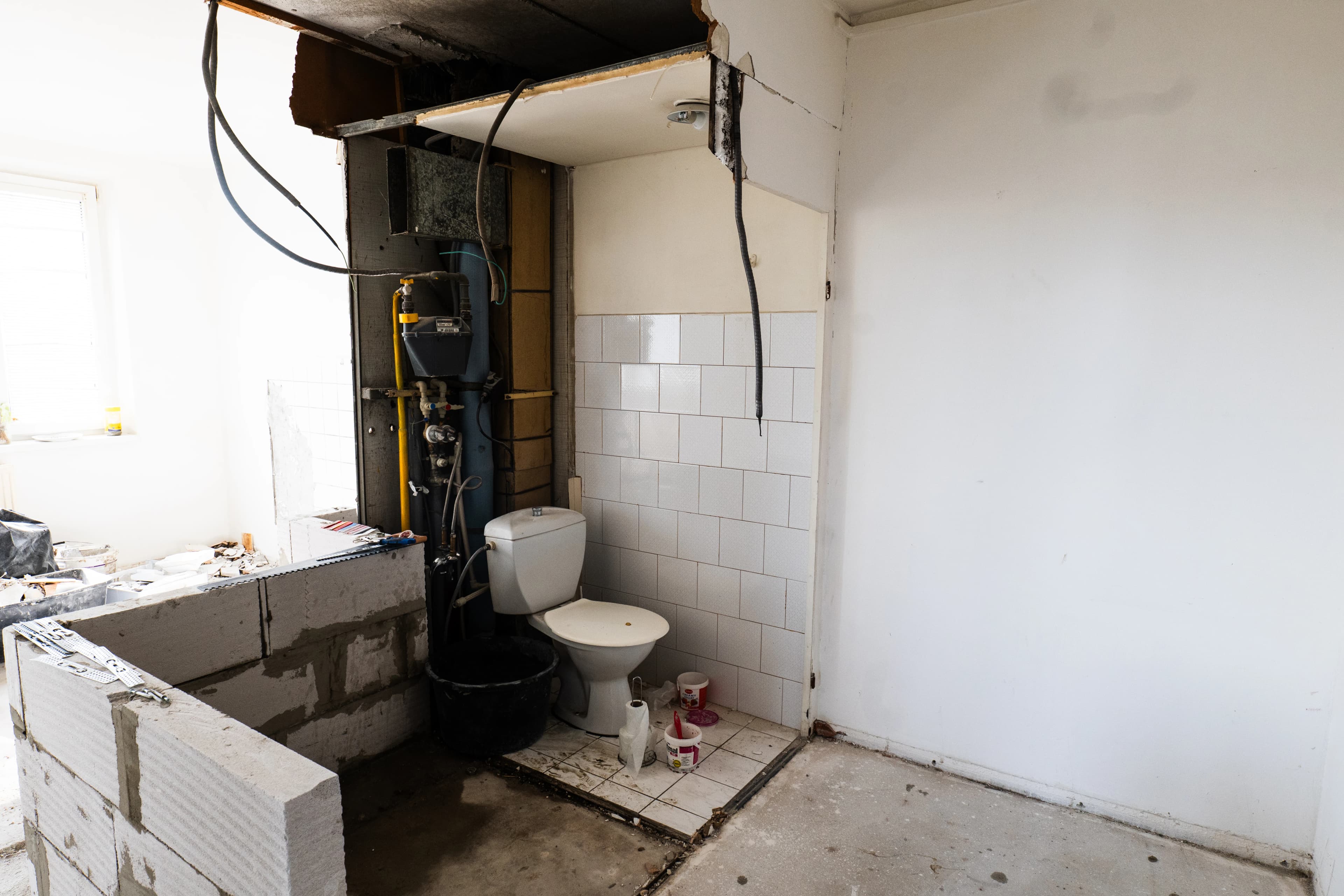 Štýlová tmavá kuchyňa s moderným osvetlením, zlatými akcentmi a elegantným jedálenským stolom.