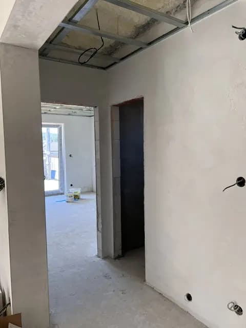 Moderná kancelária v minimalistickom štýle s elegantnými pracovnými stolmi a prírodnými materiálmi.