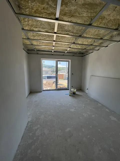 Moderná kancelária v minimalistickom štýle s elegantnými pracovnými stolmi a prírodnými materiálmi.