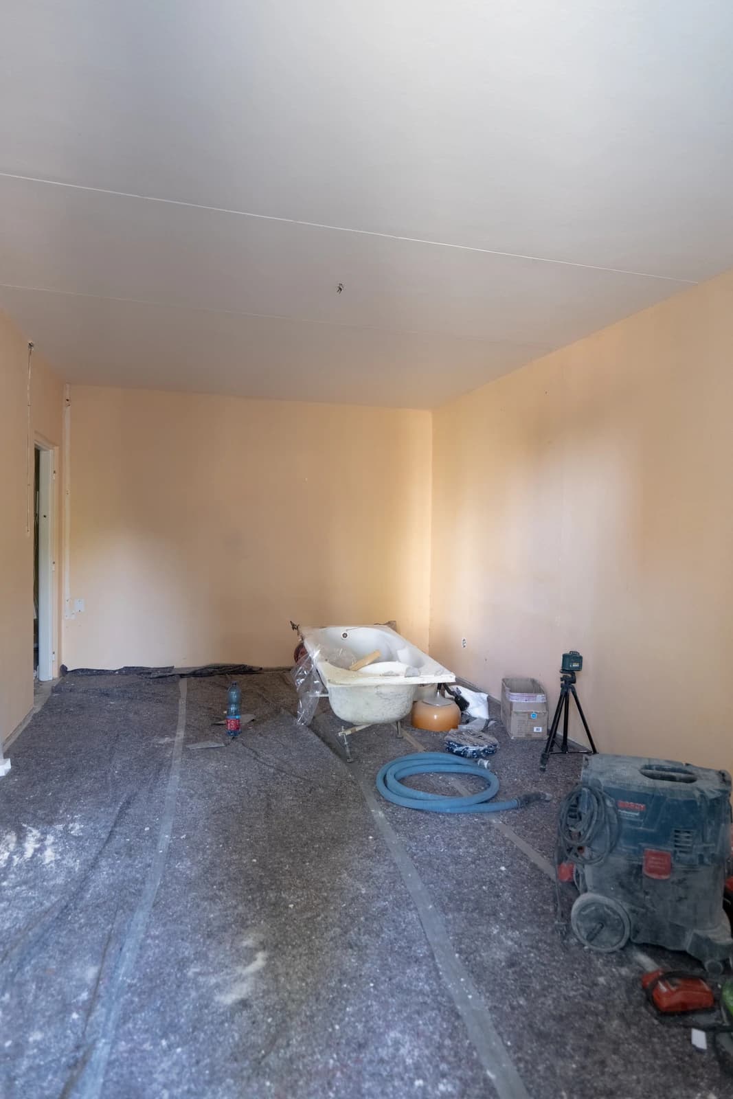 Štýlová tmavá kuchyňa s moderným osvetlením, zlatými akcentmi a elegantným jedálenským stolom.